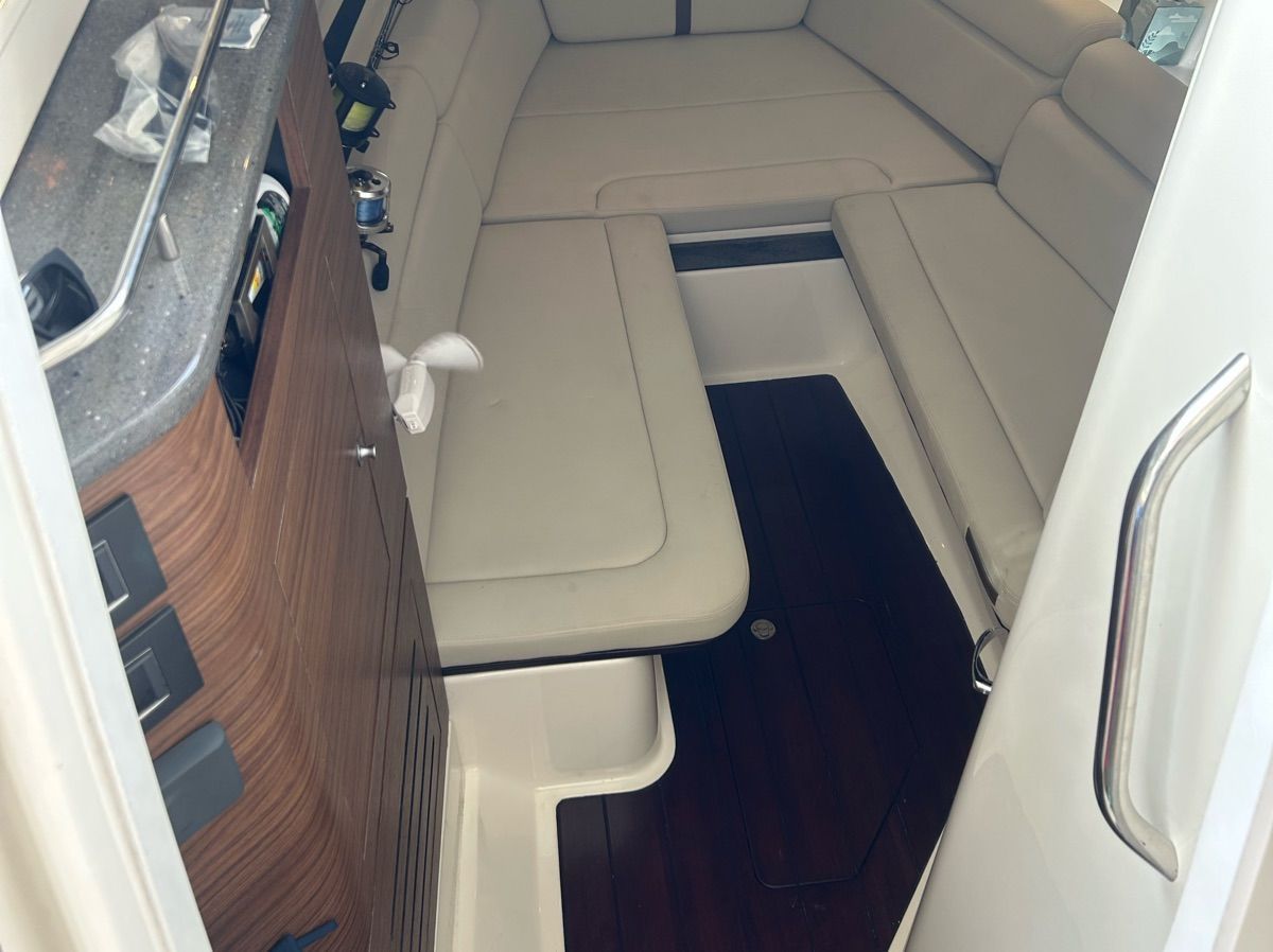 Interior of a 2021 Boston Whaler 350 Realm with cushioned seating and wooden flooring.