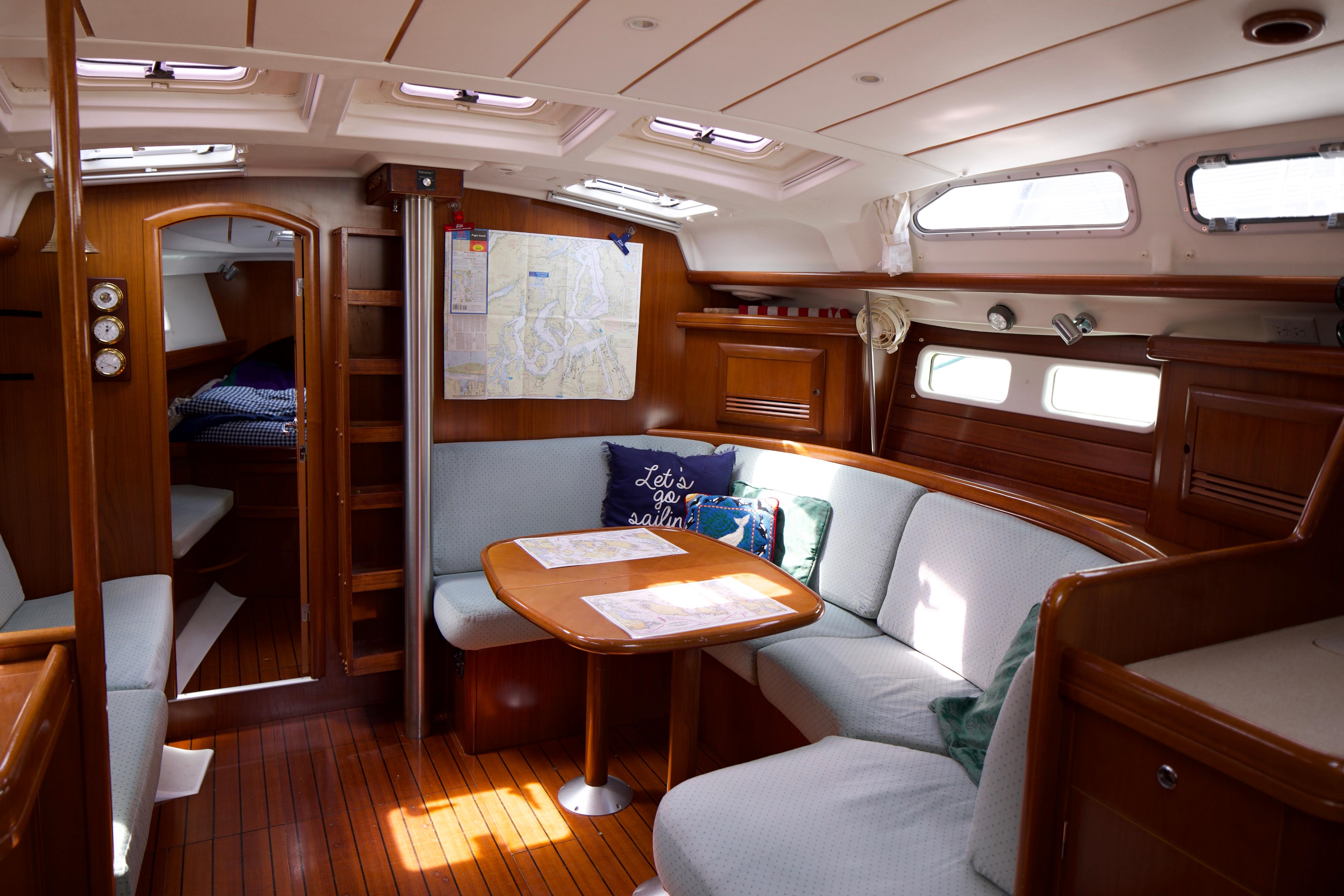 Interior of a 2005 Beneteau 423 sailboat with cozy seating and nautical decor.