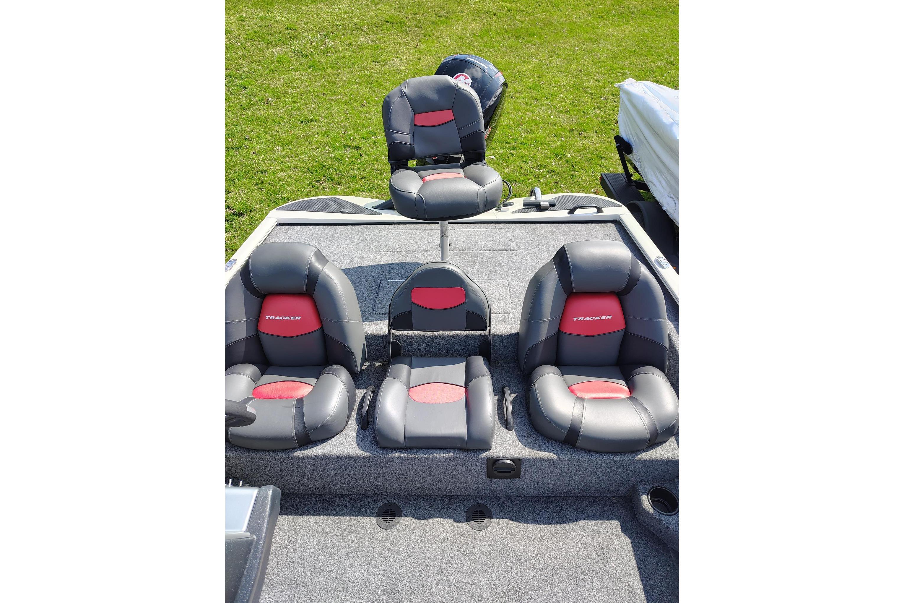 2025 Tracker Savage 215 boat interior with four cushioned seats on grassy background.