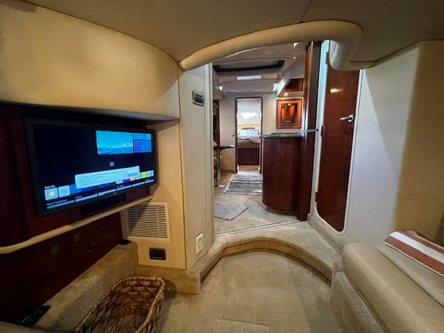 Interior of a 2006 Sea Ray 44 Sundancer yacht with TV and elegant furnishings.