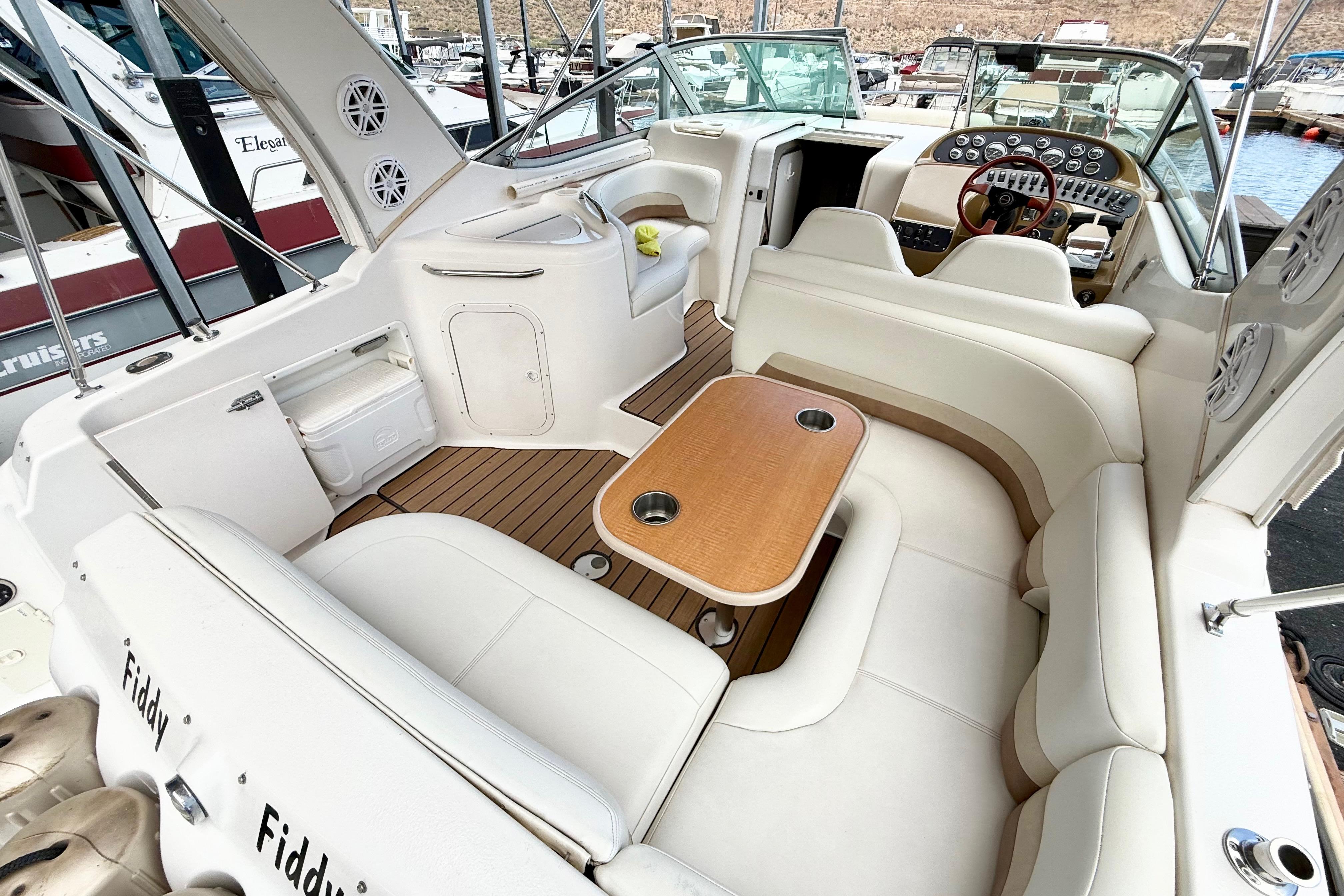 1999 Chaparral Signature 300 boat interior with white seating and wooden table.