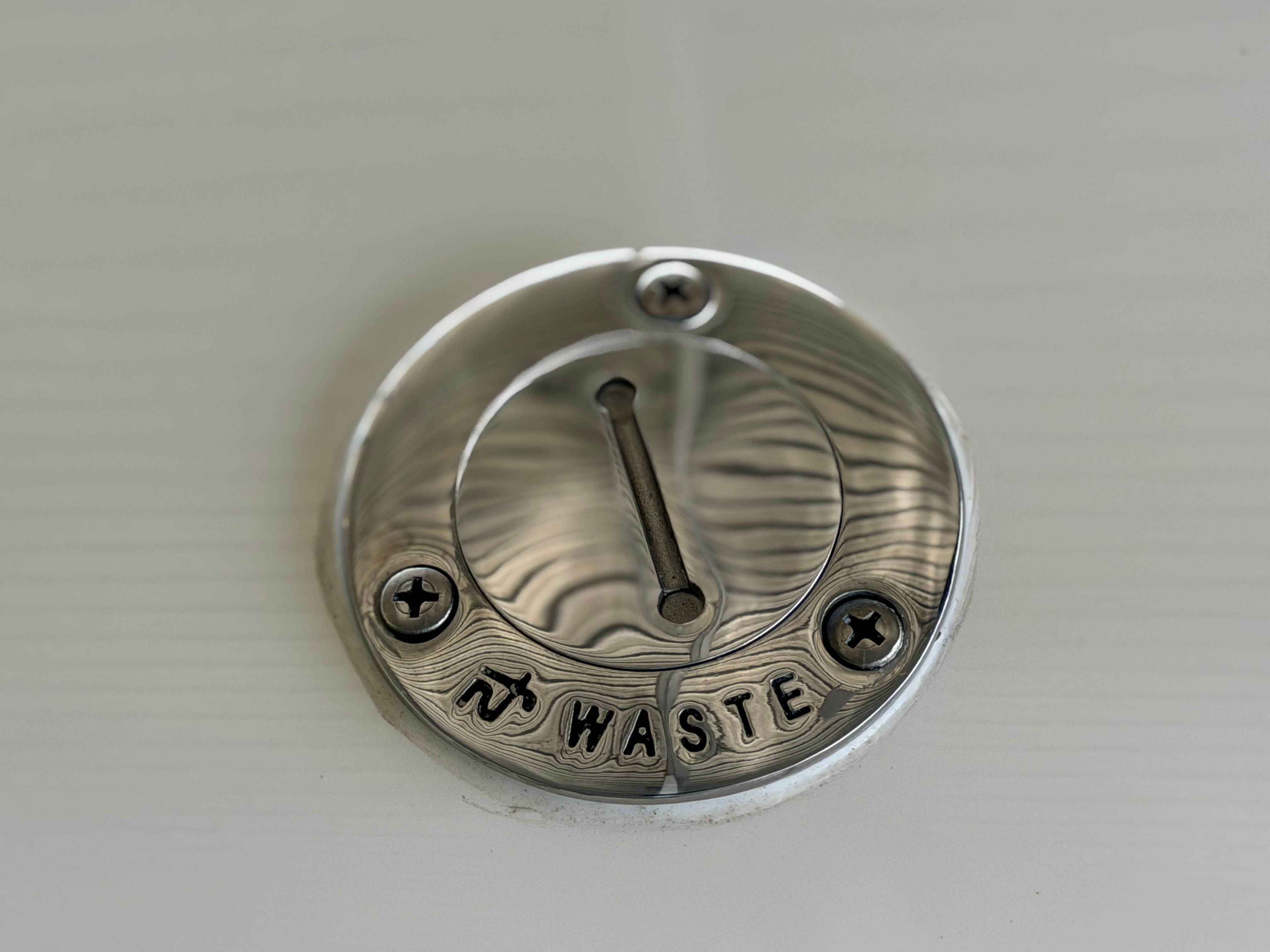 Drain cover with "Waste" engraving, Bryant 255, 2010.
