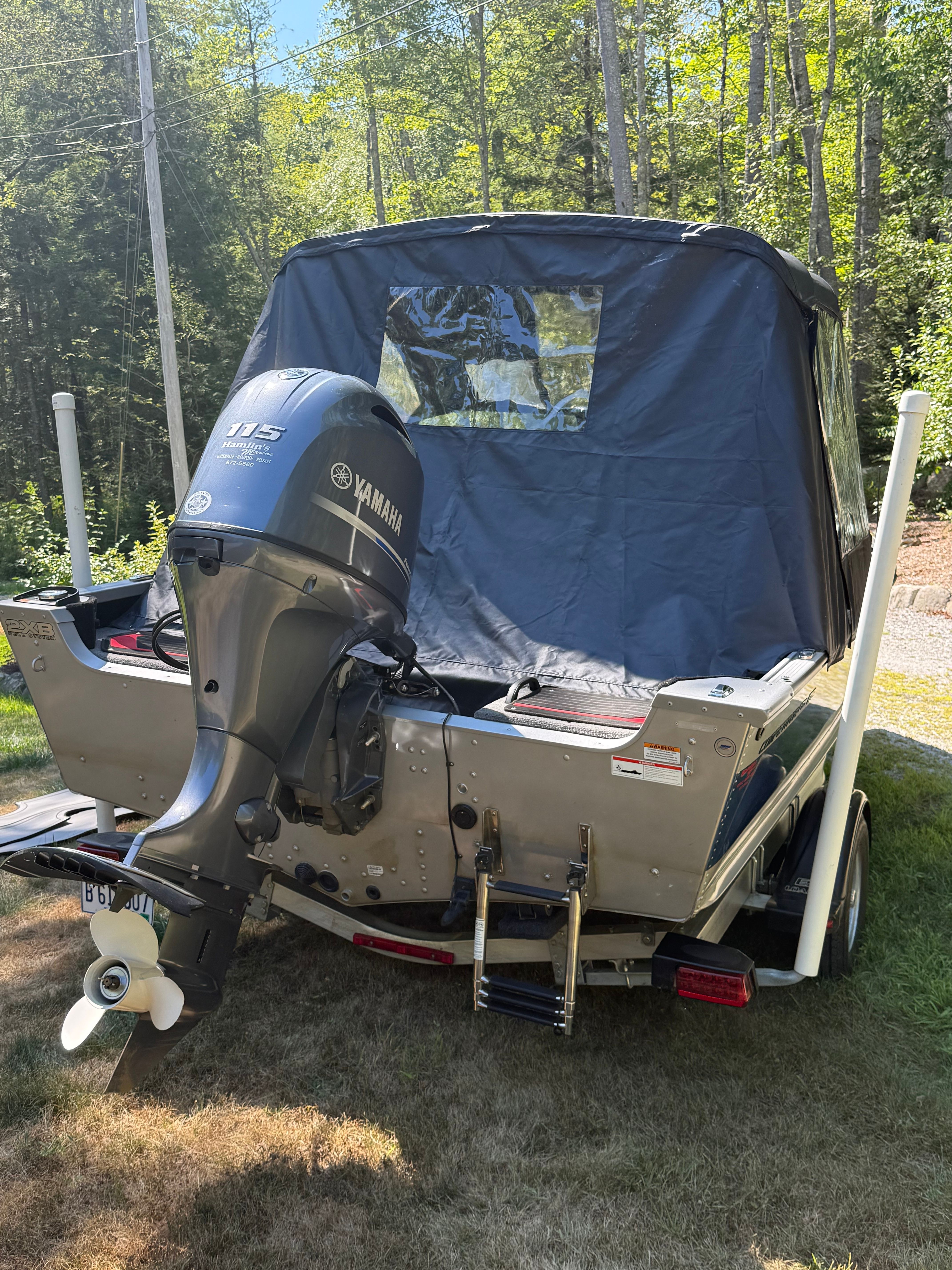 Alumacraft Competitor 175 Sport 2022 with Yamaha outboard motor, parked on a trailer in a wooded area.