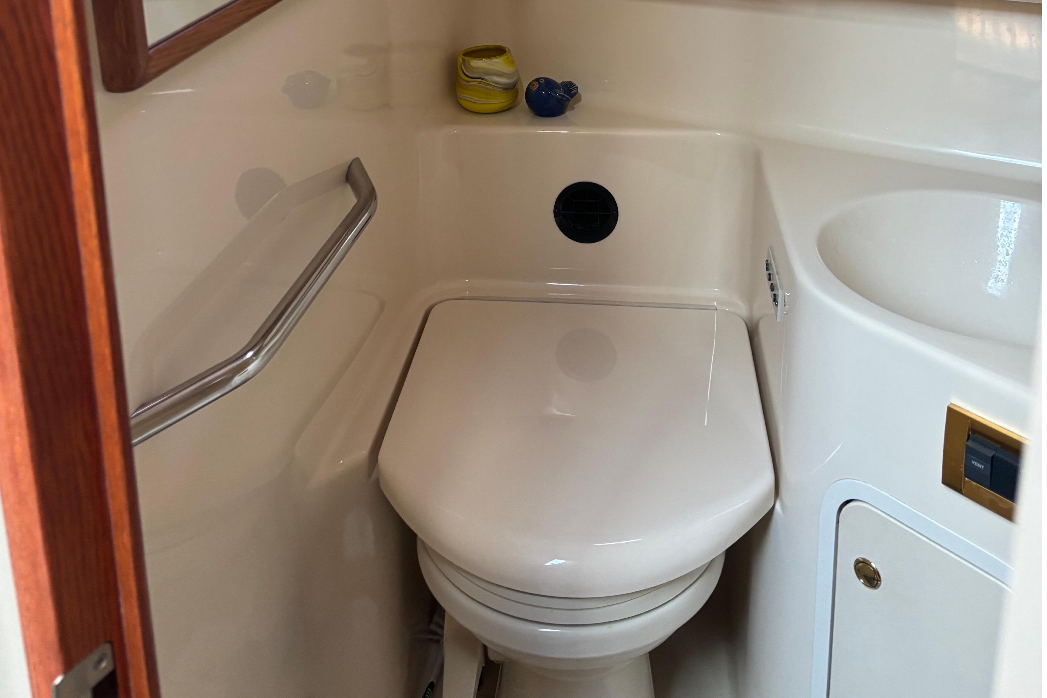 Compact bathroom in 2000 Sea Ray 420 Aft Cabin yacht with toilet and sink.