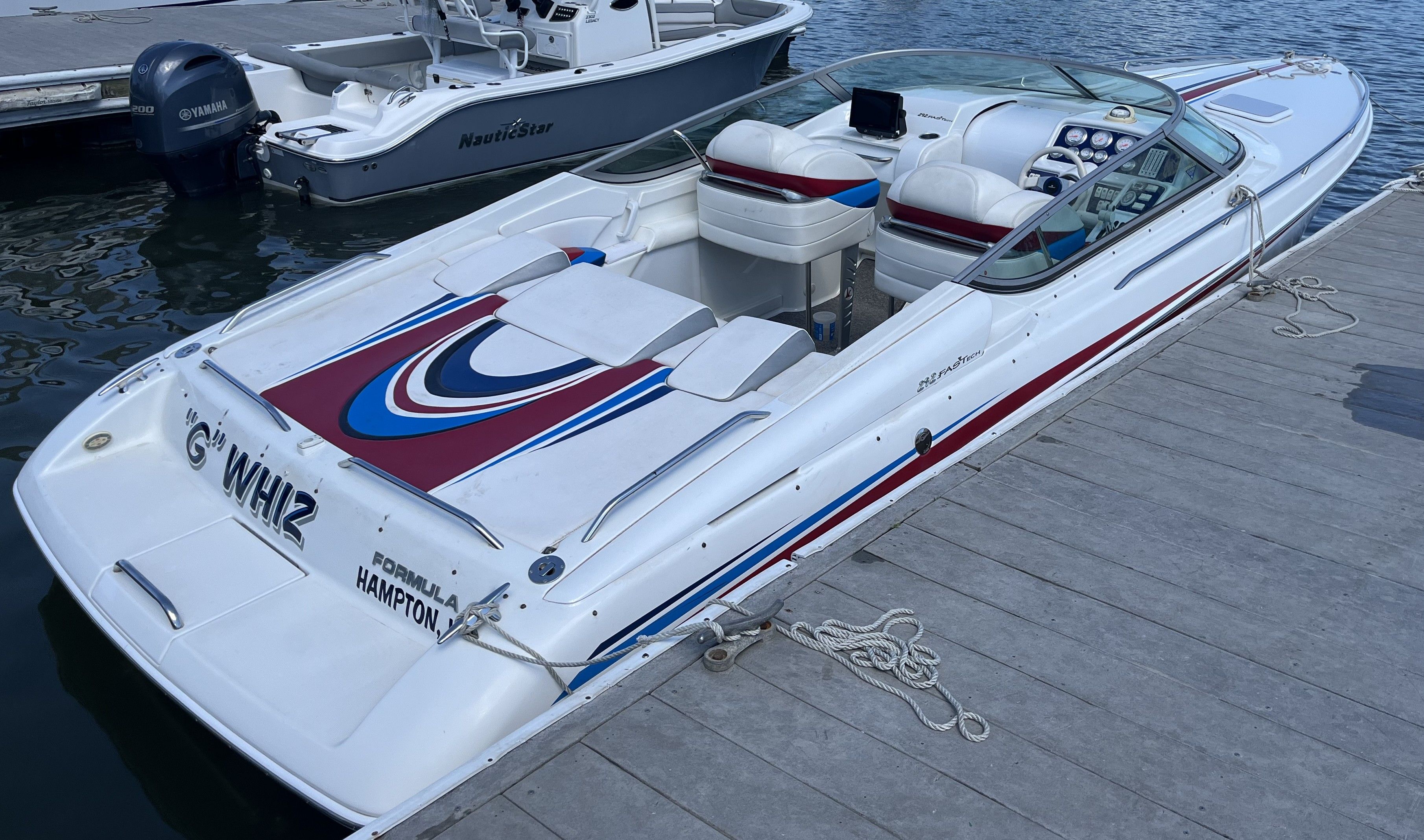 A 2004 Formula 292 FASTech boat docked. It features a sporty design with colorful accents.