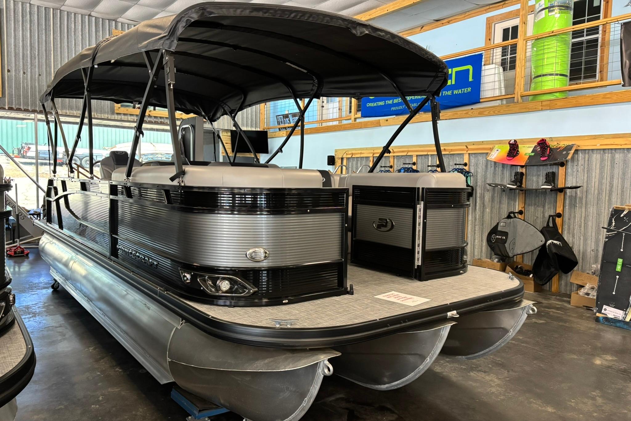 2024 Princecraft Quorum 23 RL pontoon boat displayed indoors with accessories.