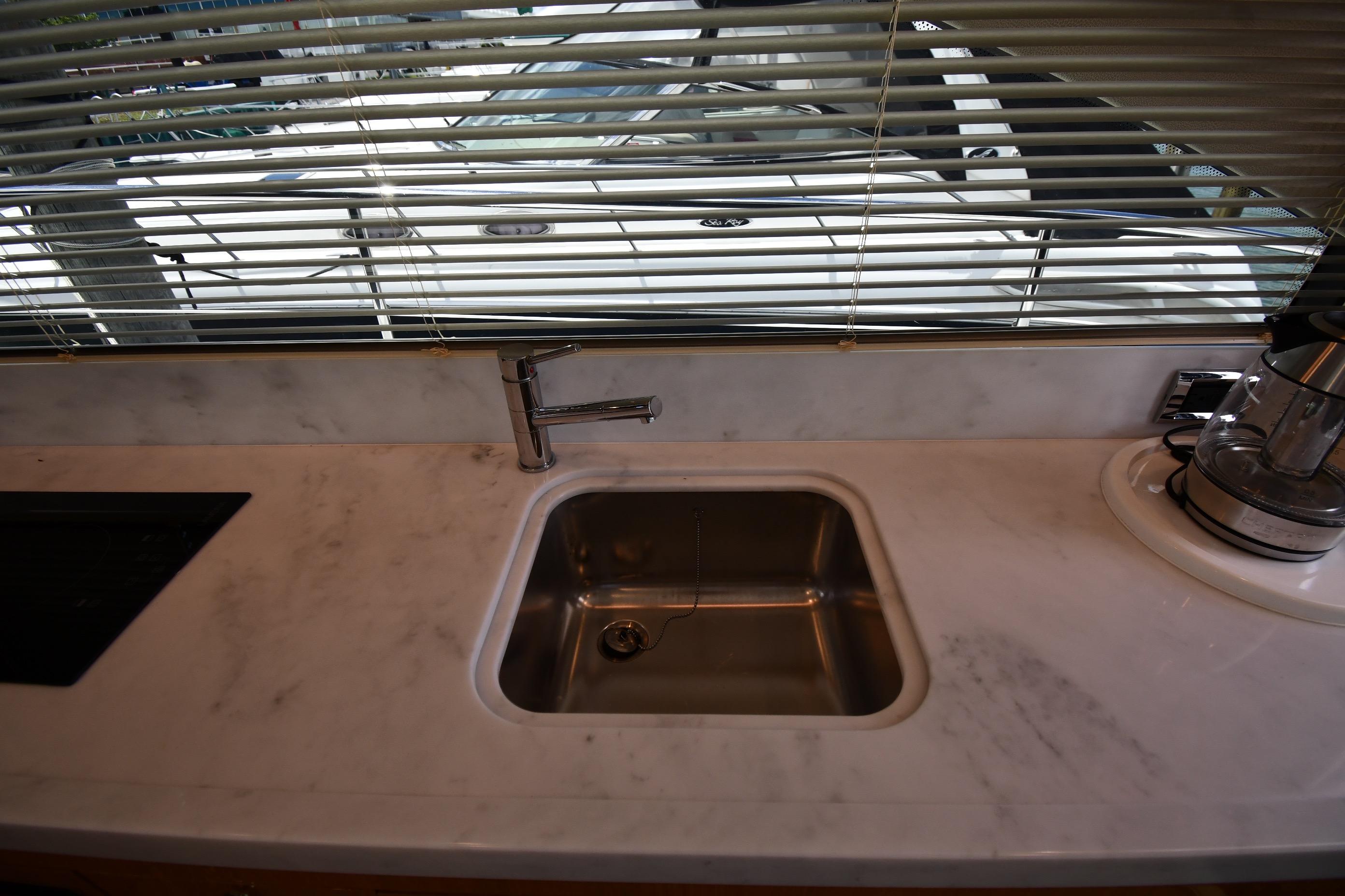 Modern kitchen sink in 2024 Fairline G50 Targa yacht with marble countertop.