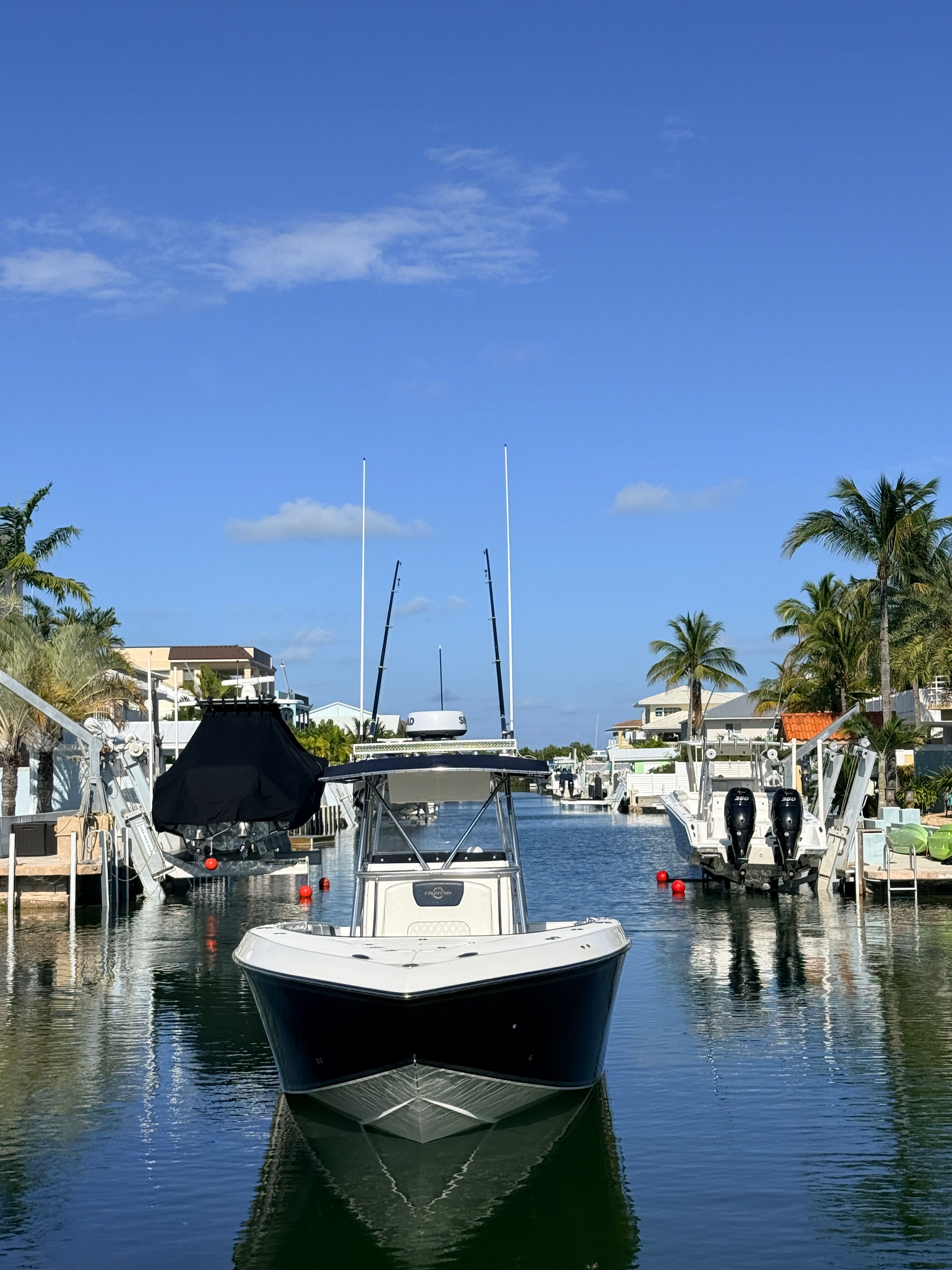 2007 Fountain 32 Center Console boat in sunny canal.
