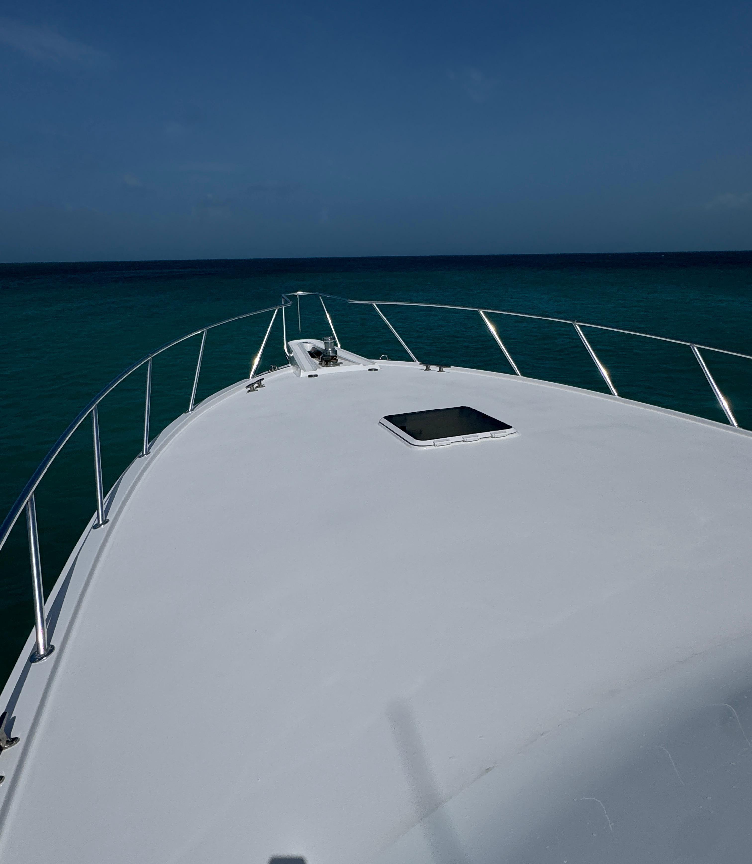 Bow view of 2005 Hatteras 50 Convertible yacht on open sea.
