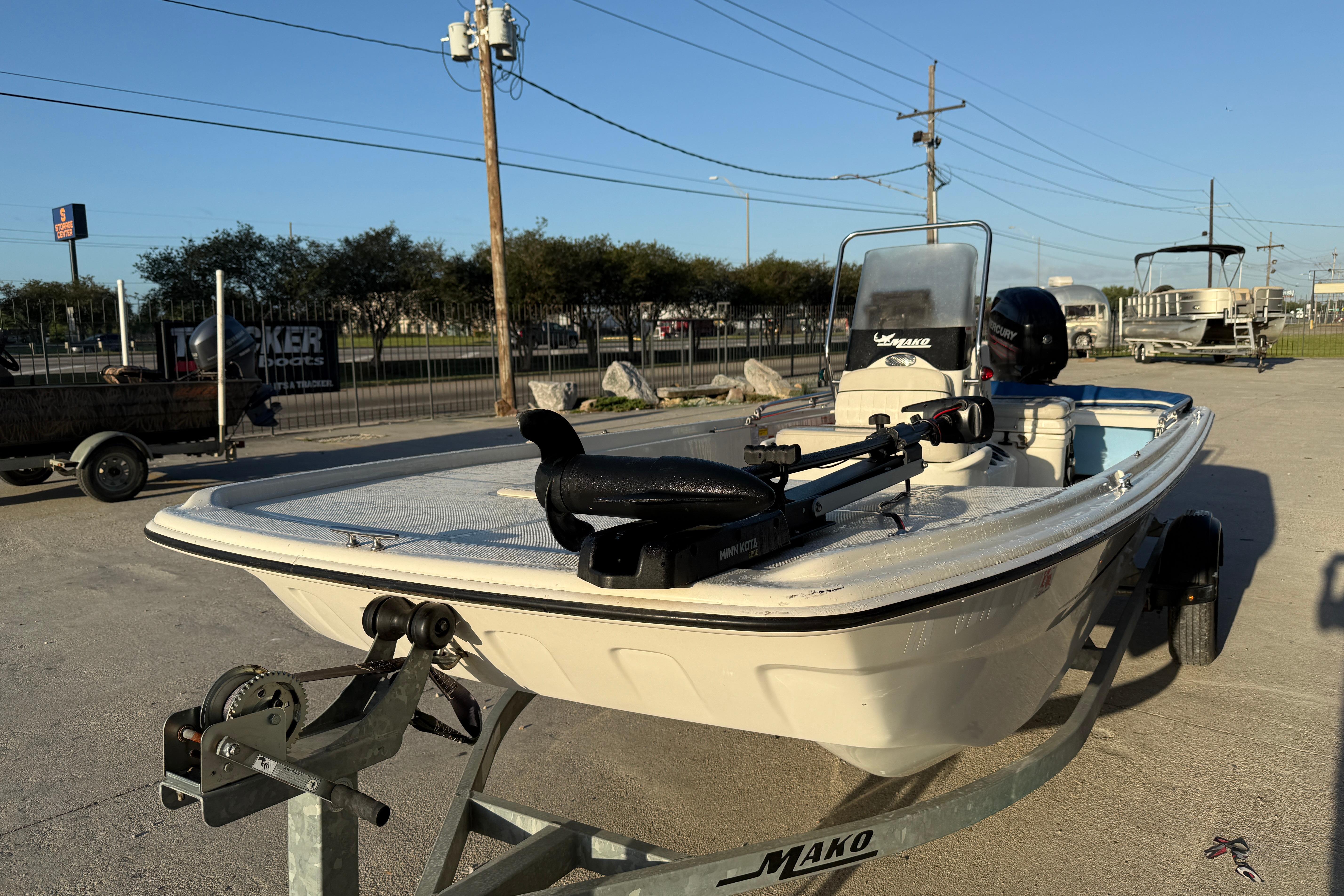 2017 Mako Pro Skiff 17 CC boat on trailer, parked outdoors under clear sky.