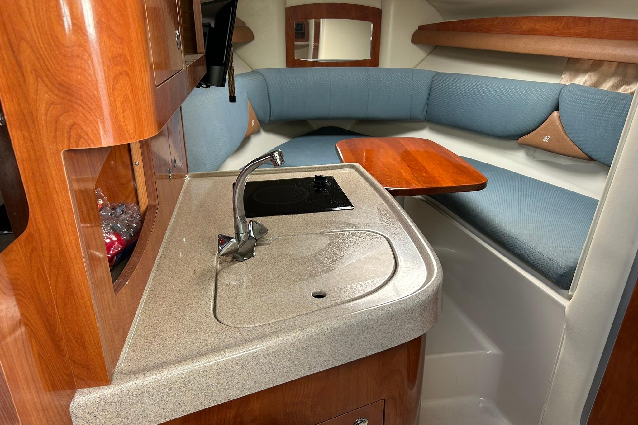 2006 Four Winns 288 Vista cabin interior with kitchenette and seating area.