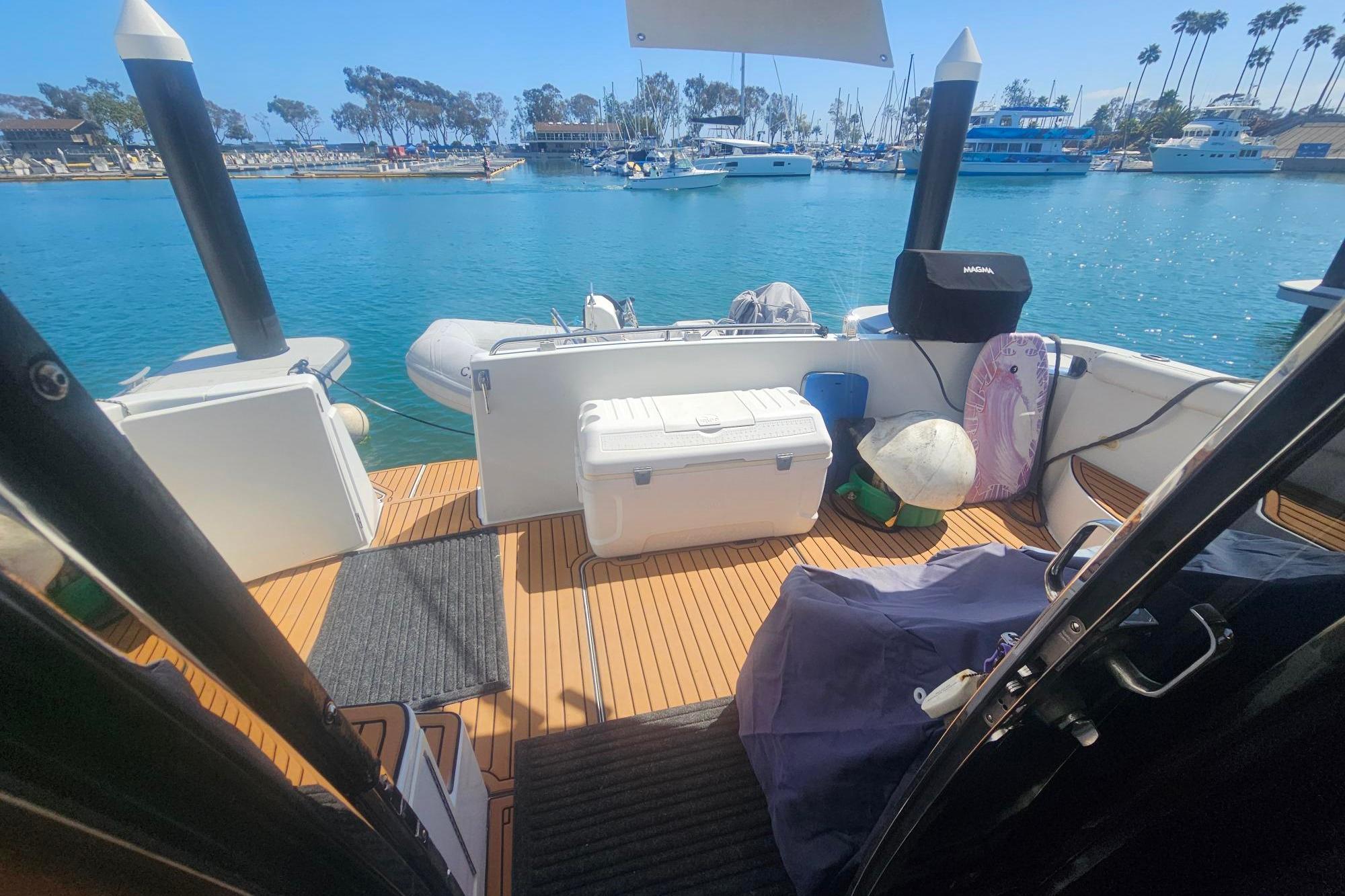 2002 Carver 450 Voyager Pilothouse deck with cooler, docked in a sunny marina.