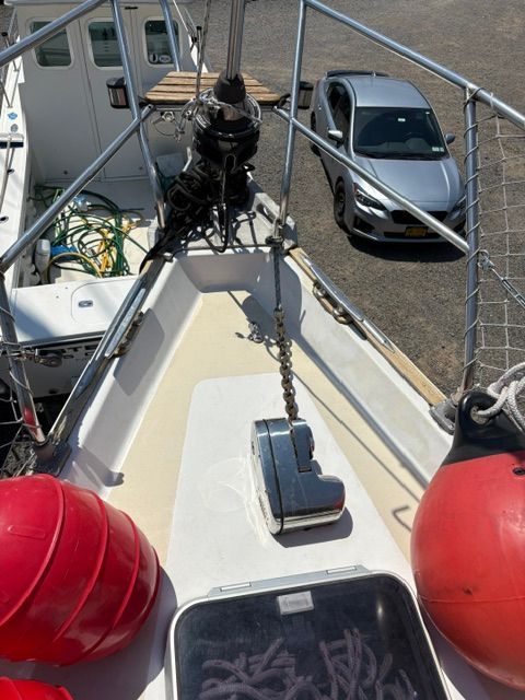Deck of a 1983 C&C Landfall with anchor windlass and fenders.
