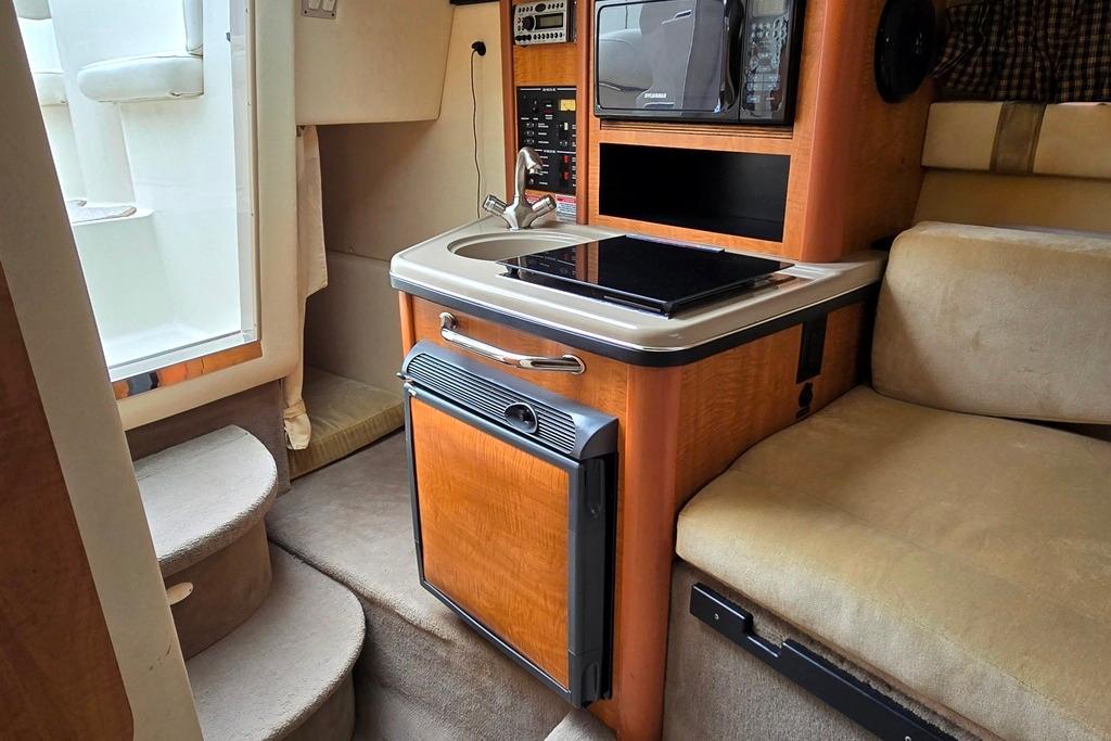Interior of 2006 Sea Ray 240 Sundancer boat with kitchenette and seating area.
