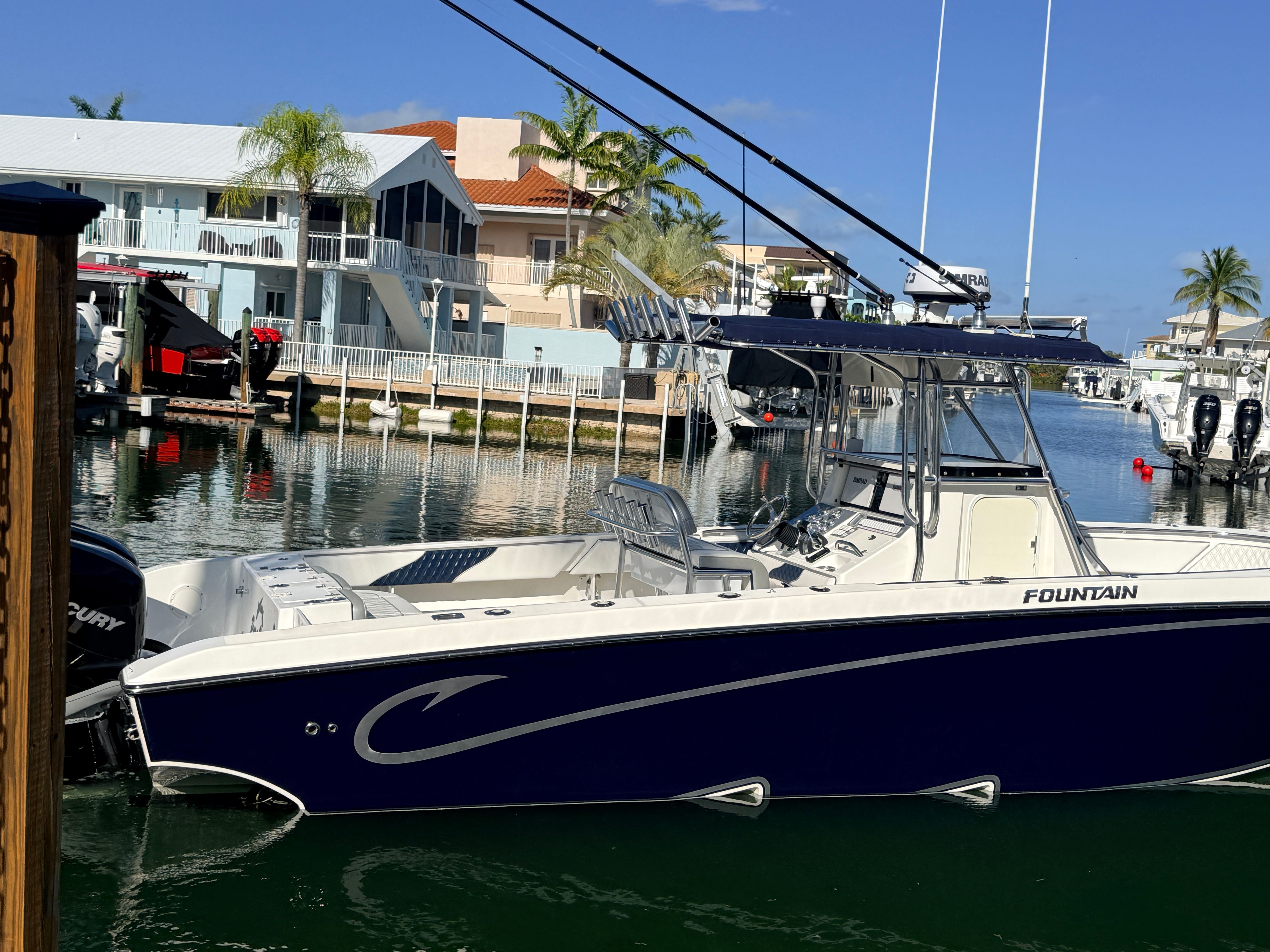 2007 Fountain 32 Center Console boat docked in harbor.