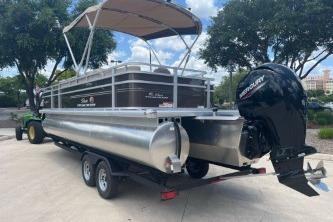 2025 Sun Tracker Sportfish 24 XP3 pontoon boat on trailer, featuring Mercury outboard motor.