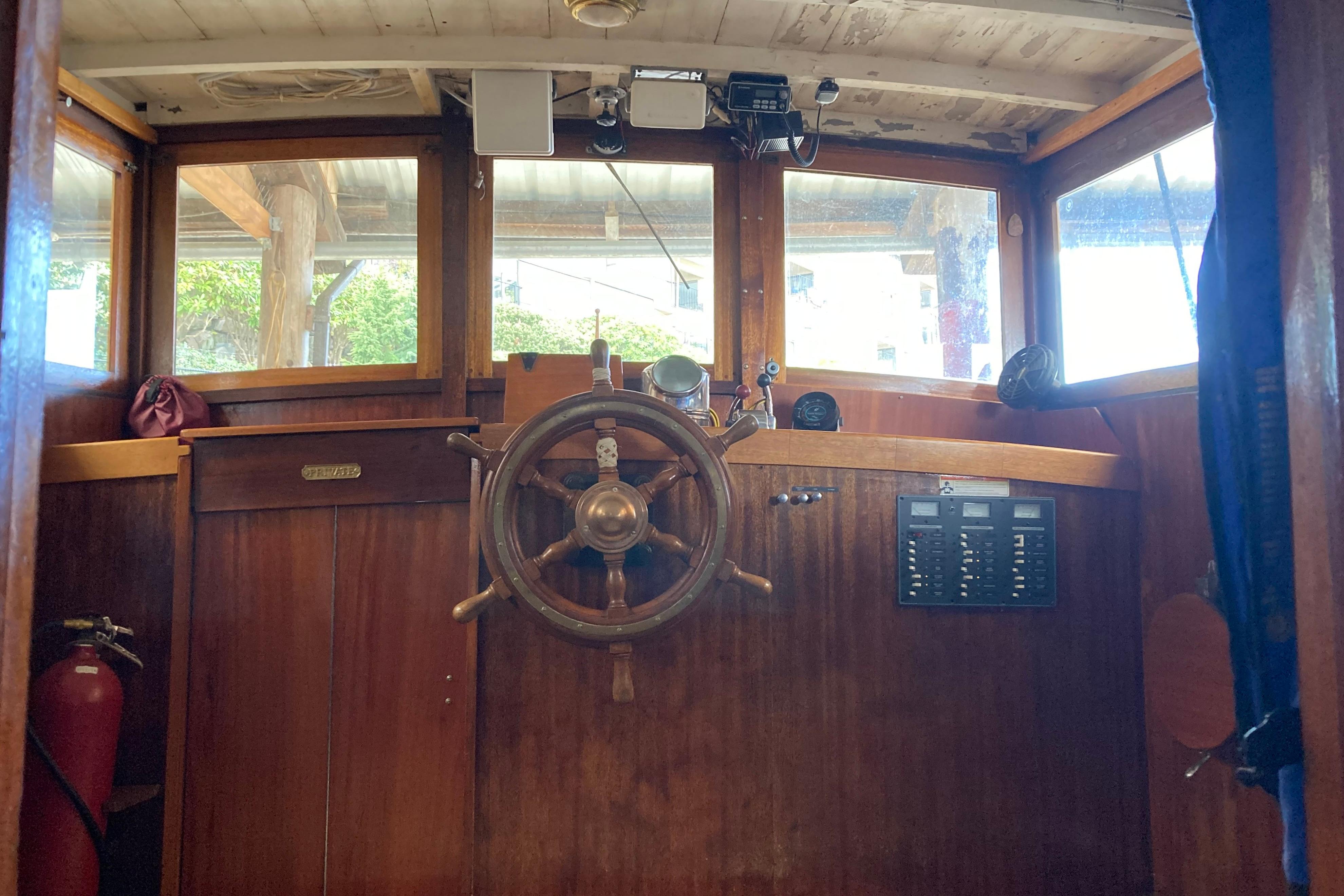 Interior of a 1942 Grenfell 42 Custom boat with wooden steering wheel and control panel.