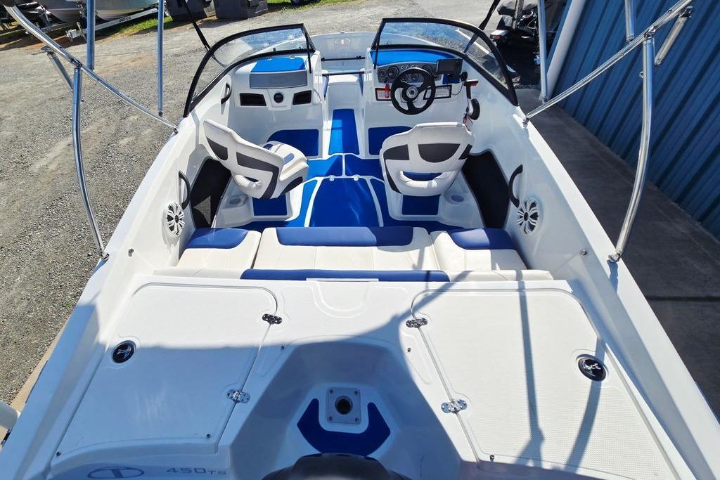 2018 Tahoe 450 TS boat interior with blue and white seating, steering wheel, and dashboard.