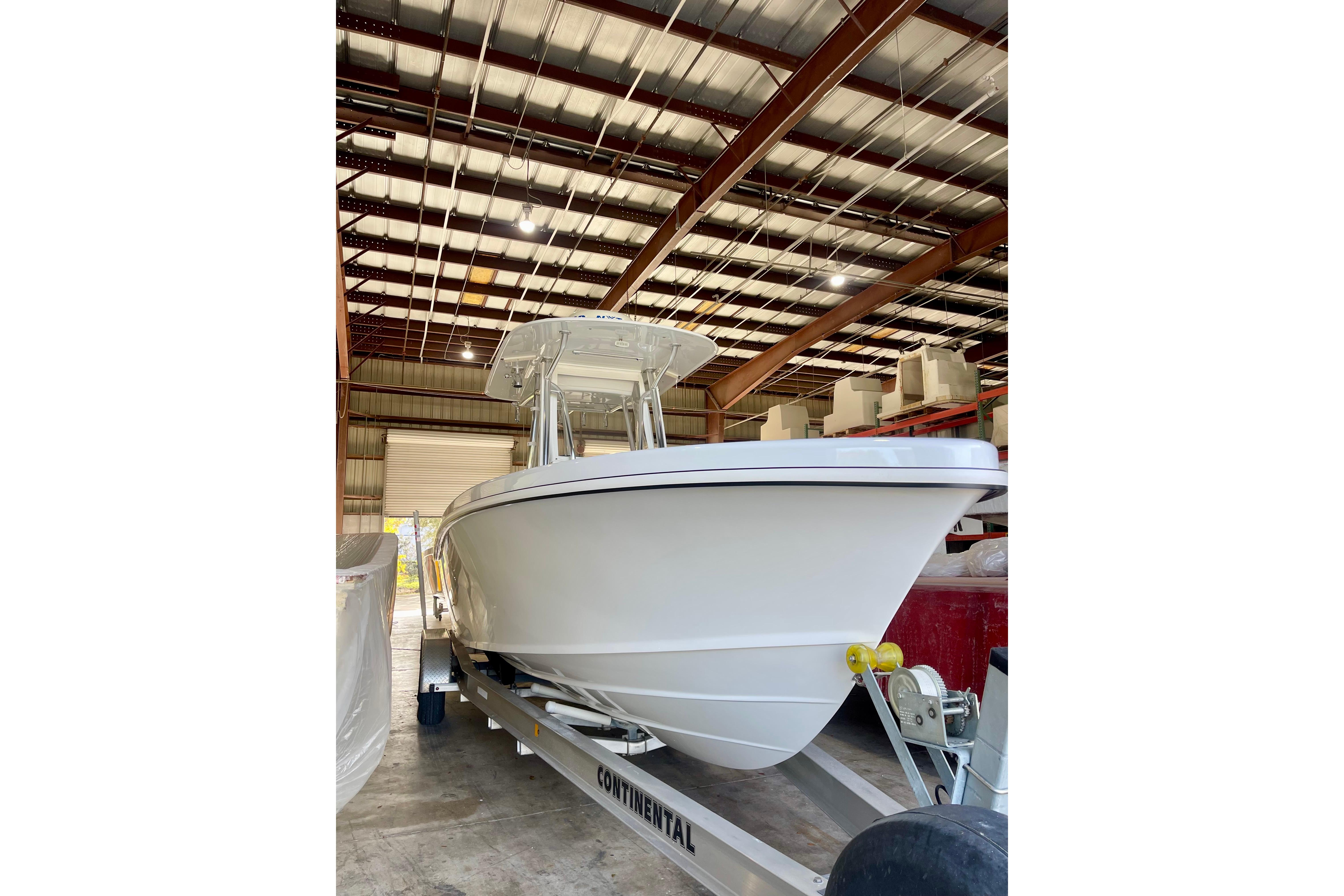2025 Ocean Master 296 Center Console boat in a warehouse on a trailer.