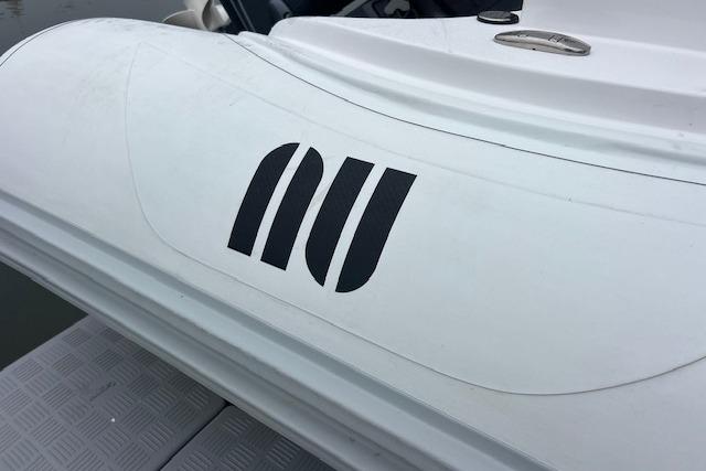 2023 Novurania Como 18 boat with distinctive logo on white surface.