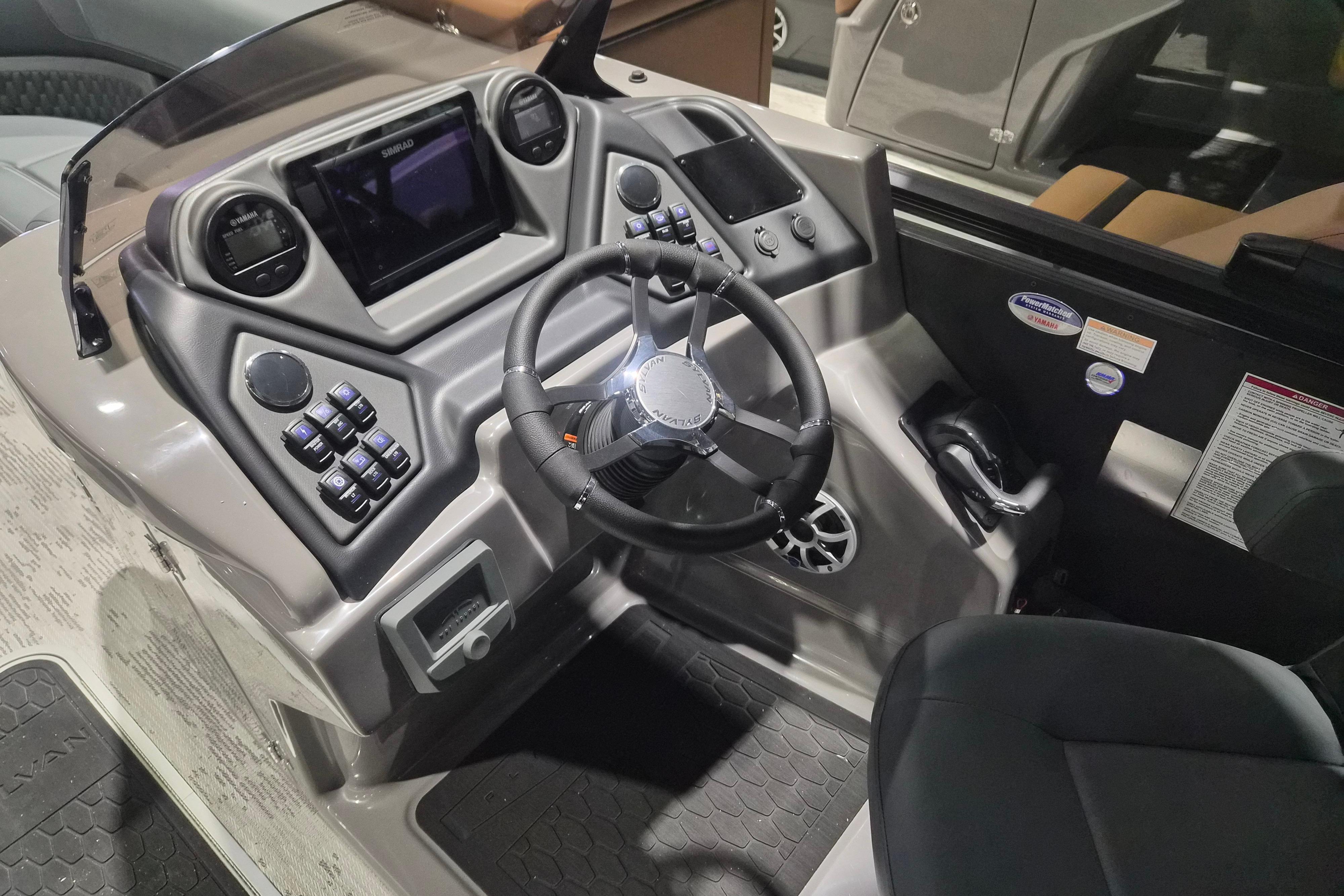 2026 Sylvan L3 ULZ boat dashboard with steering wheel, controls, and display screens.