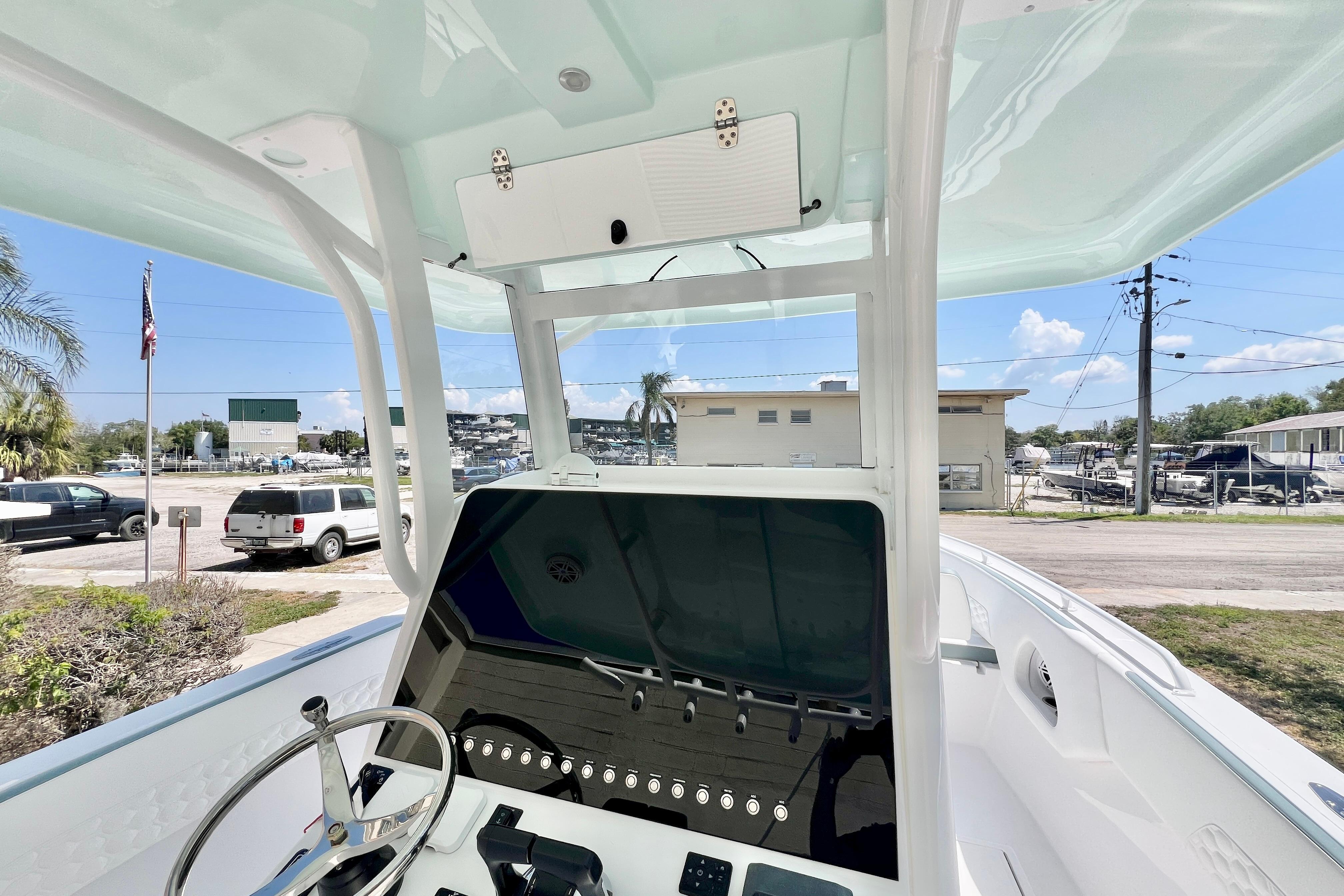 2026 Stamas 31T Aventura boat console with steering wheel, docked outdoors.