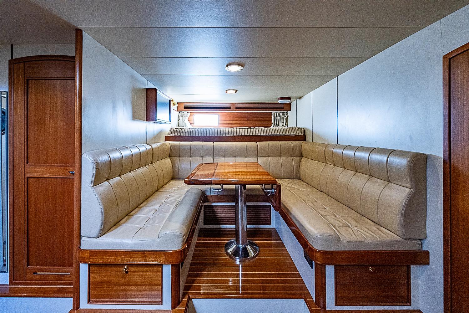 Luxurious interior of 2014 Marlow 80 Explorer yacht with elegant seating and wooden table.