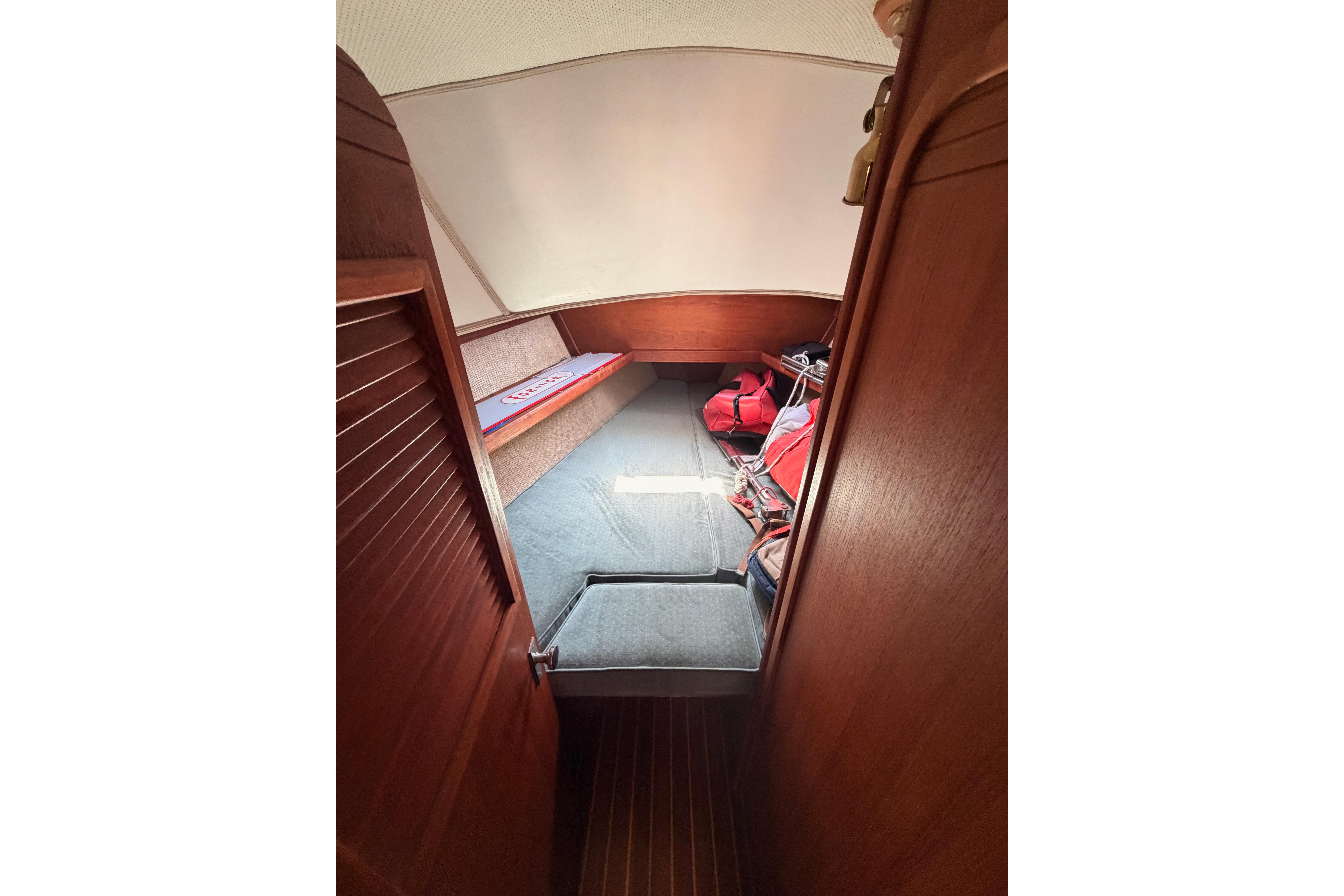 Cozy cabin interior of 1991 Caliber 33 sailboat with wooden finish and storage space.