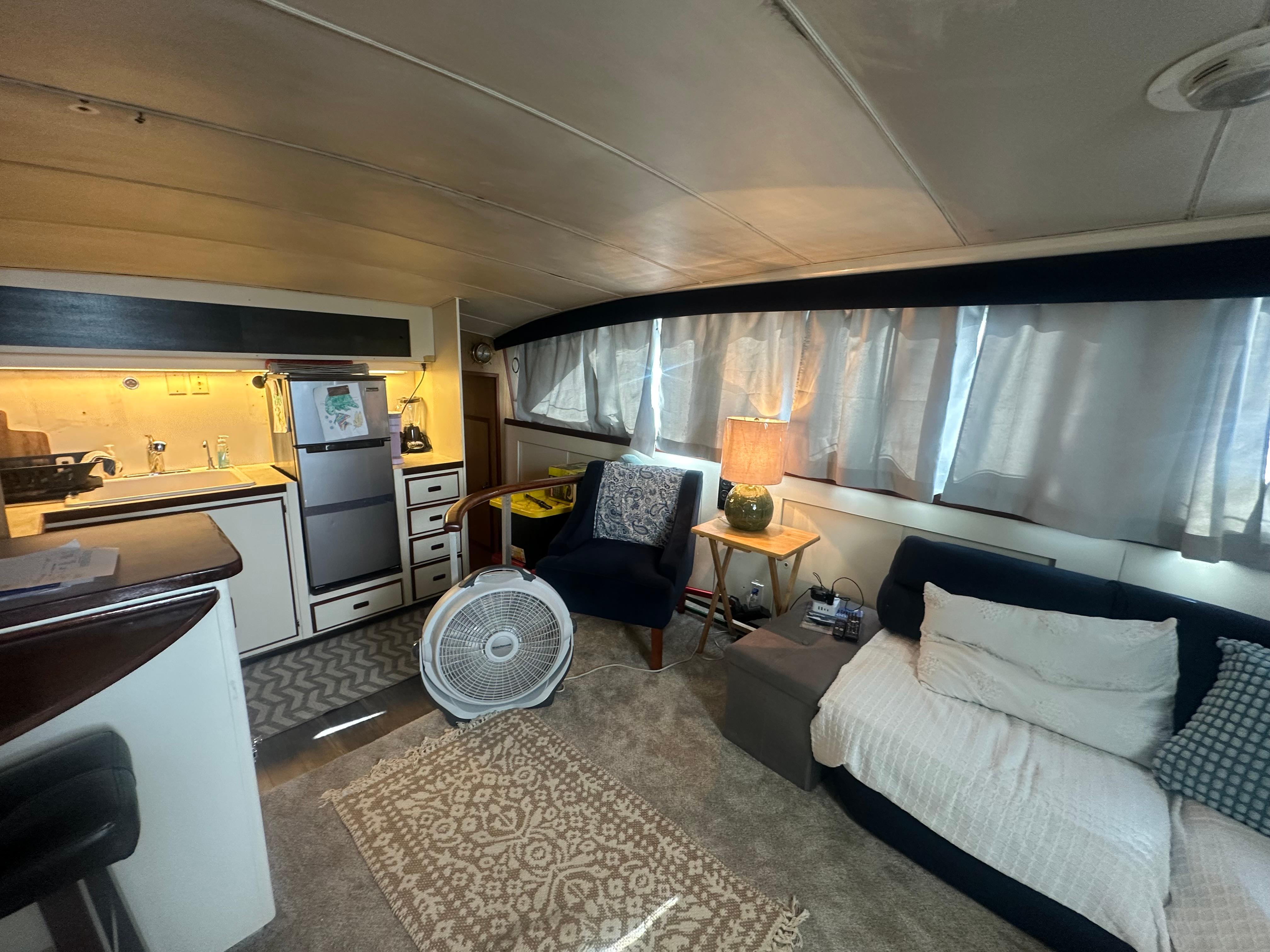 Interior of a 1974 Bertram 42 Motor Yacht with cozy seating and kitchen area.