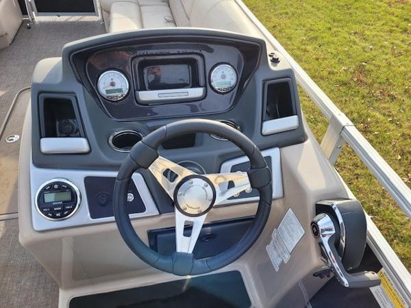 2023 Ranger Reata 243C boat dashboard with steering wheel and control panel.