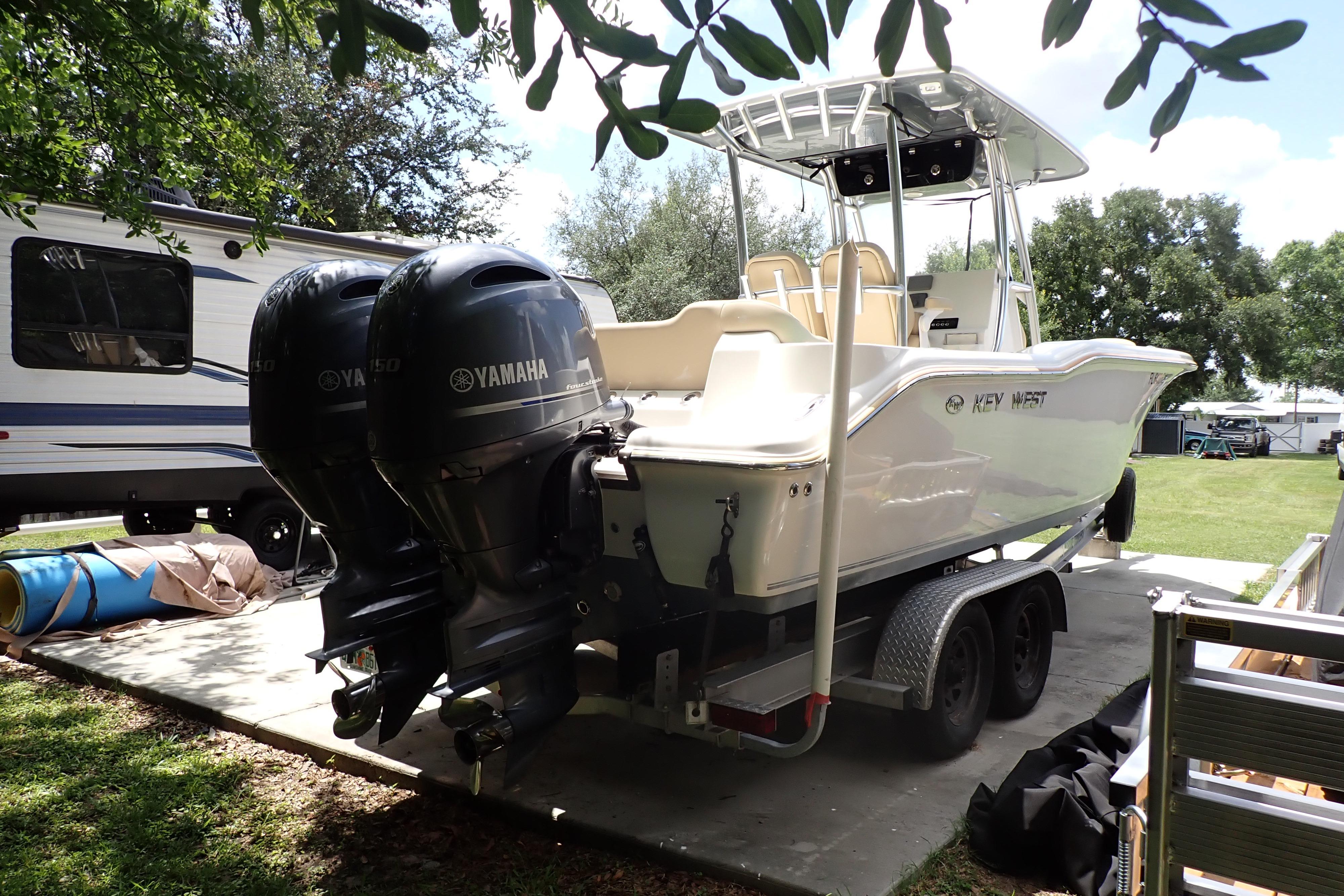 2019 Key West 263 FS boat with dual Yamaha engines on a trailer, parked outdoors.