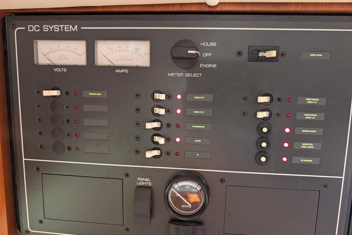 DC system control panel on a 2000 Pursuit 3400 Express boat, showing volt and amp meters.