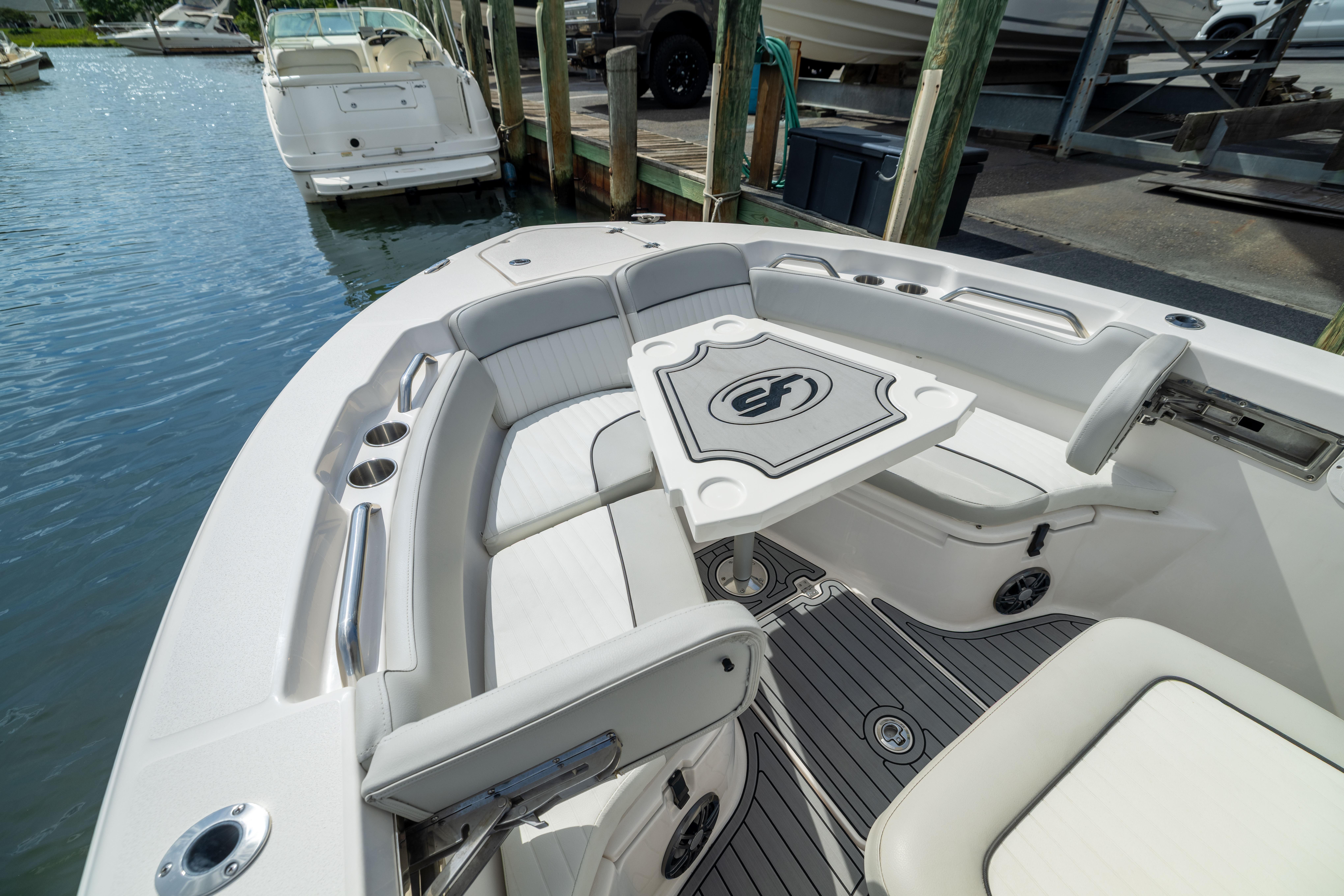 2023 Sea Fox 228 Commander boat interior with seating and table, docked by the water.