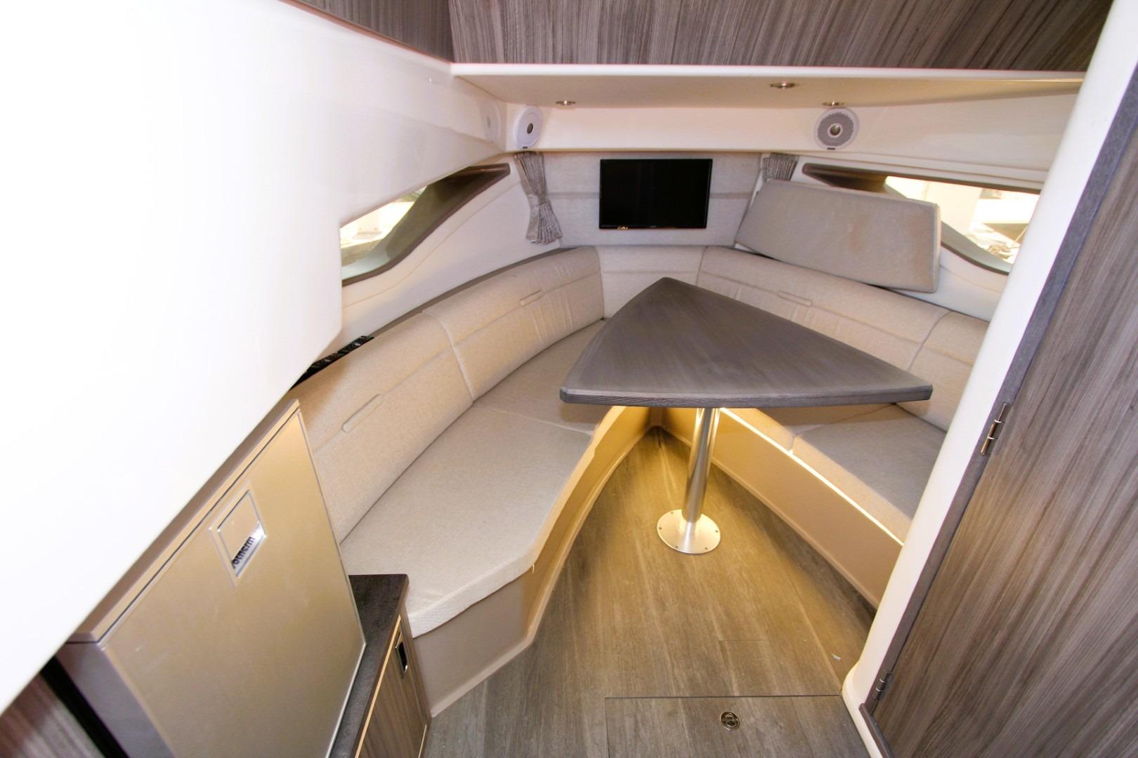 Interior of 2021 Sea Ray Sundancer 320 Outboard, featuring a cozy seating area and table.