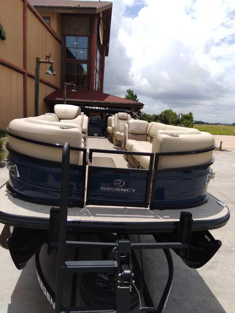 2025 Regency 250 LE3 pontoon boat with luxurious seating, parked outdoors.