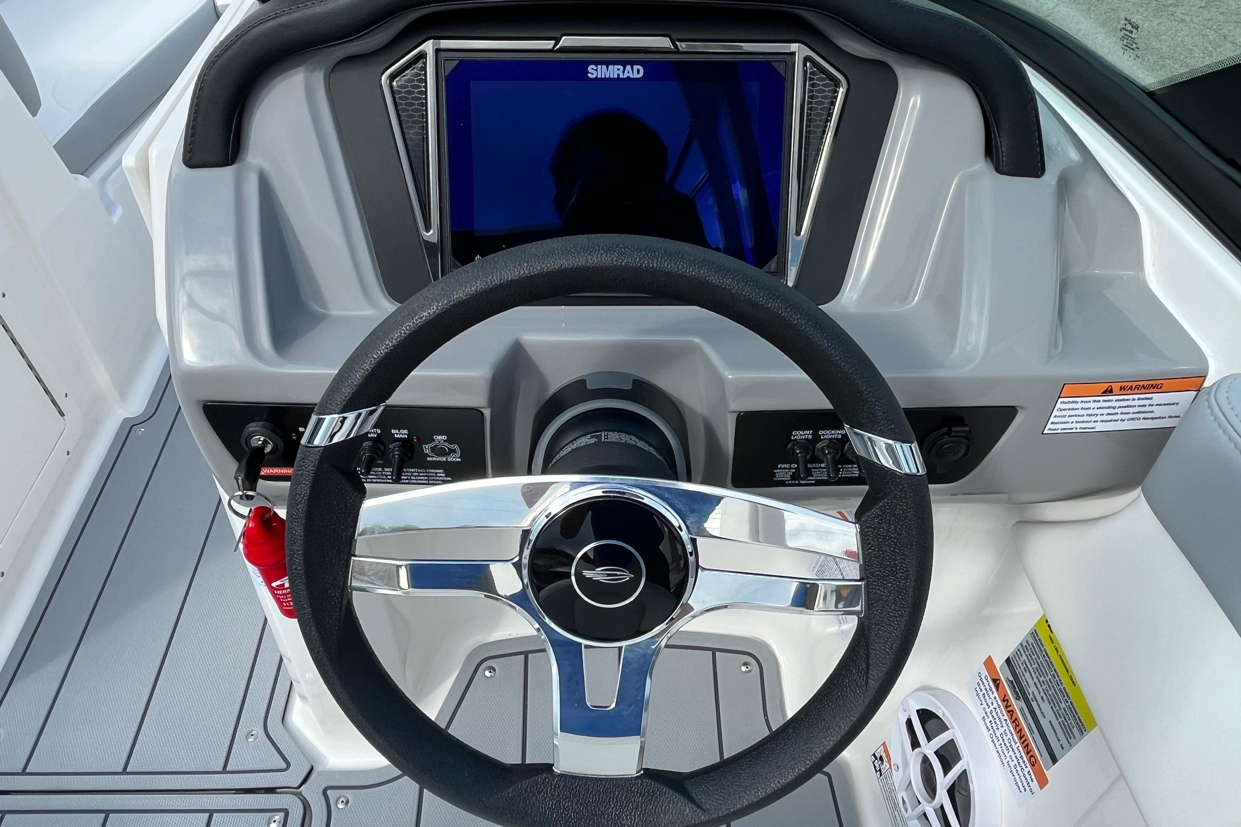 Steering wheel and dashboard of 2026 Chaparral 21 SSi boat with Simrad display.