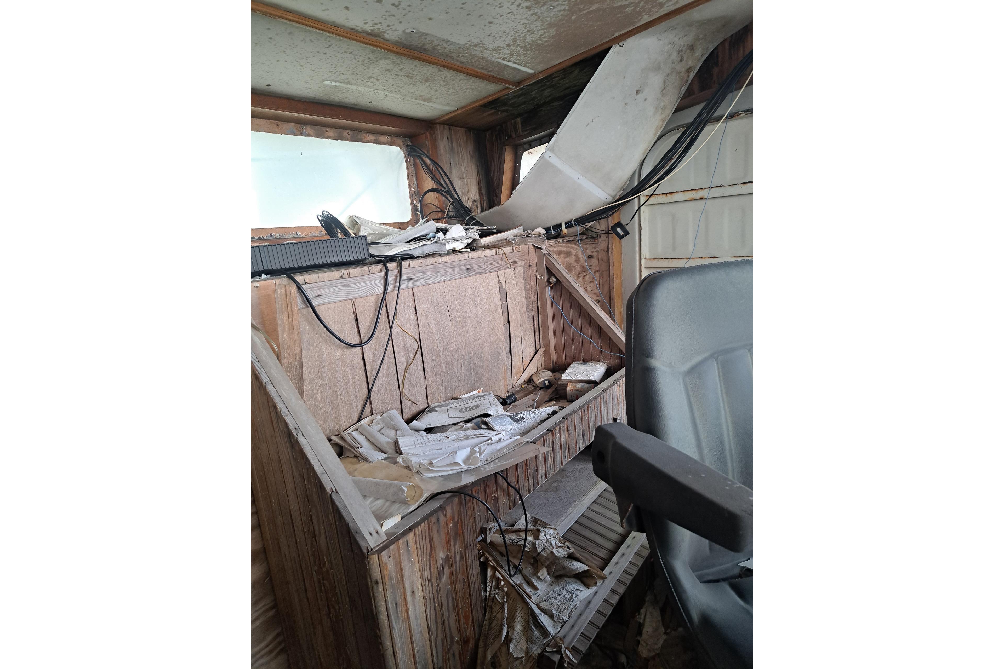 Interior of a 1979 Custom Steel Trawler Dragger, showing cluttered control area.