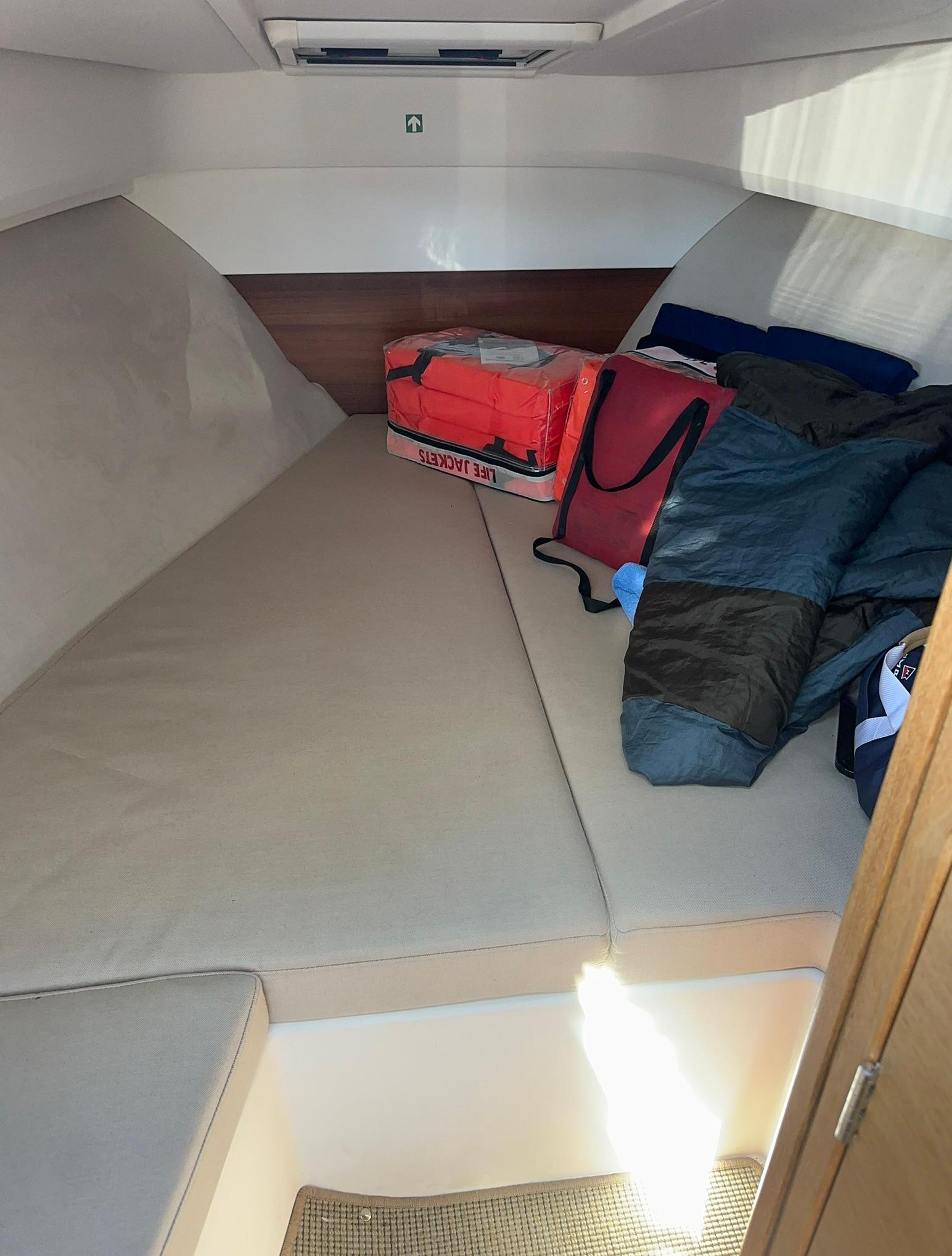 Cozy cabin interior of 2021 Nimbus W9 boat with cushions and bags.