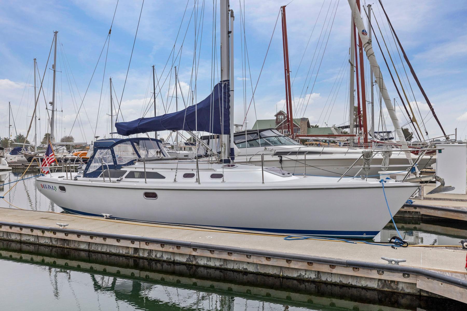 2004 Catalina 36 MkII sailboat docked at marina with blue sky background.