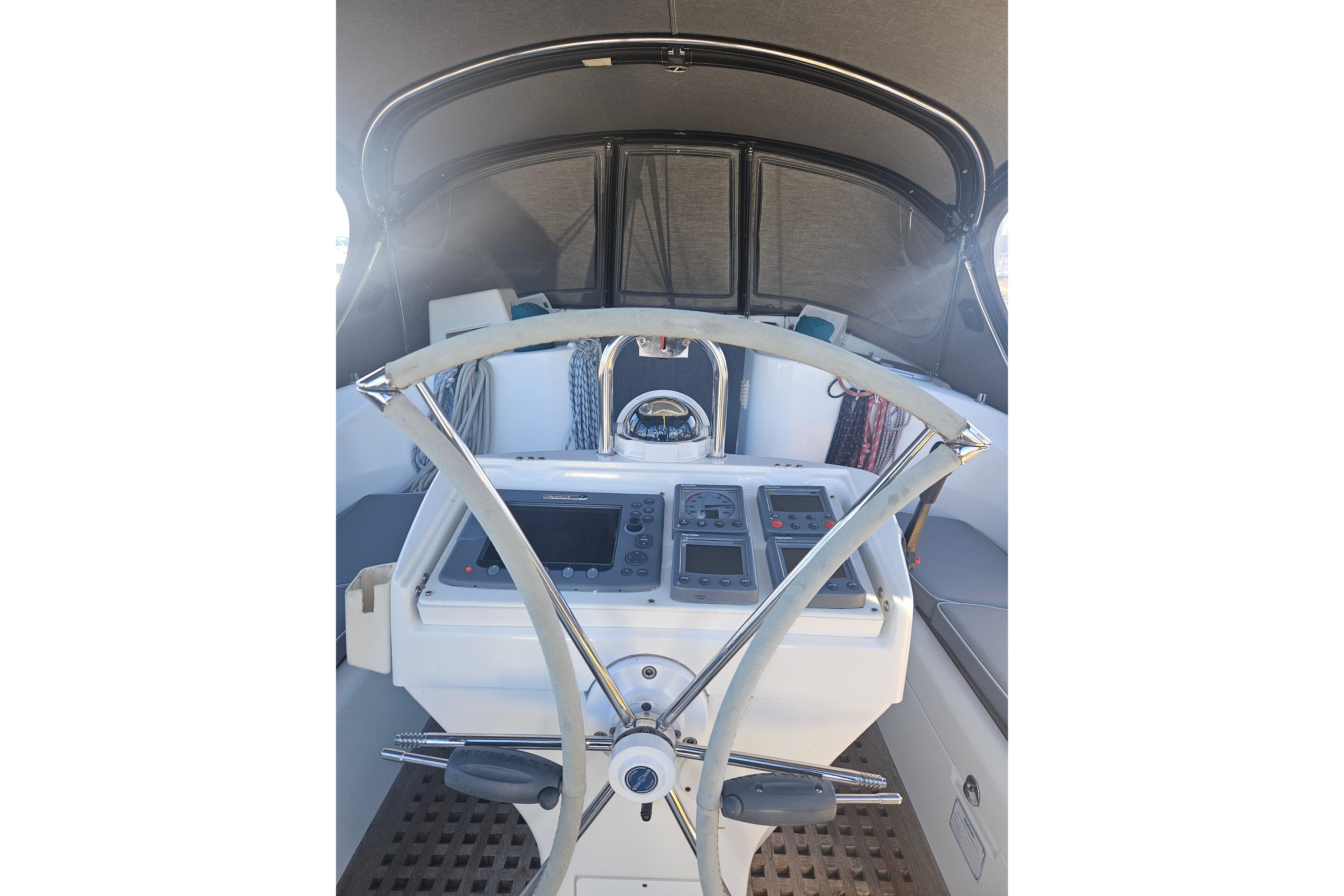 Cockpit of 1998 Beneteau 381 sailboat with steering wheel and navigation instruments.