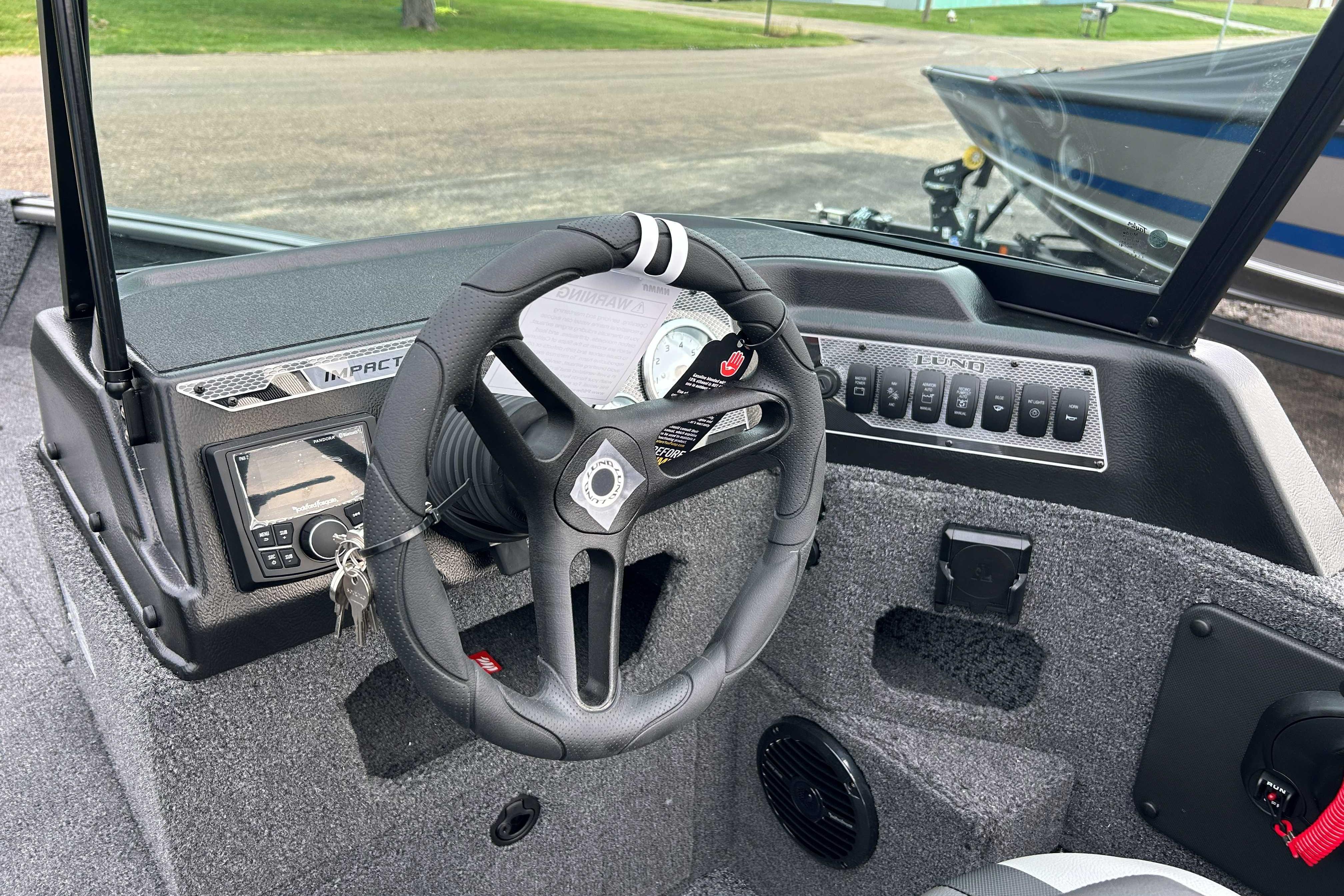 2027 Lund 1775 Impact XS boat dashboard with steering wheel and control panel.