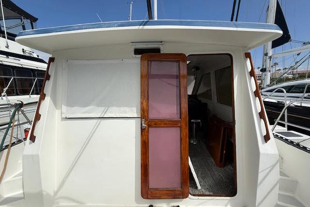 1982 Lancer 45 Motorsailer with wooden door, docked at marina.