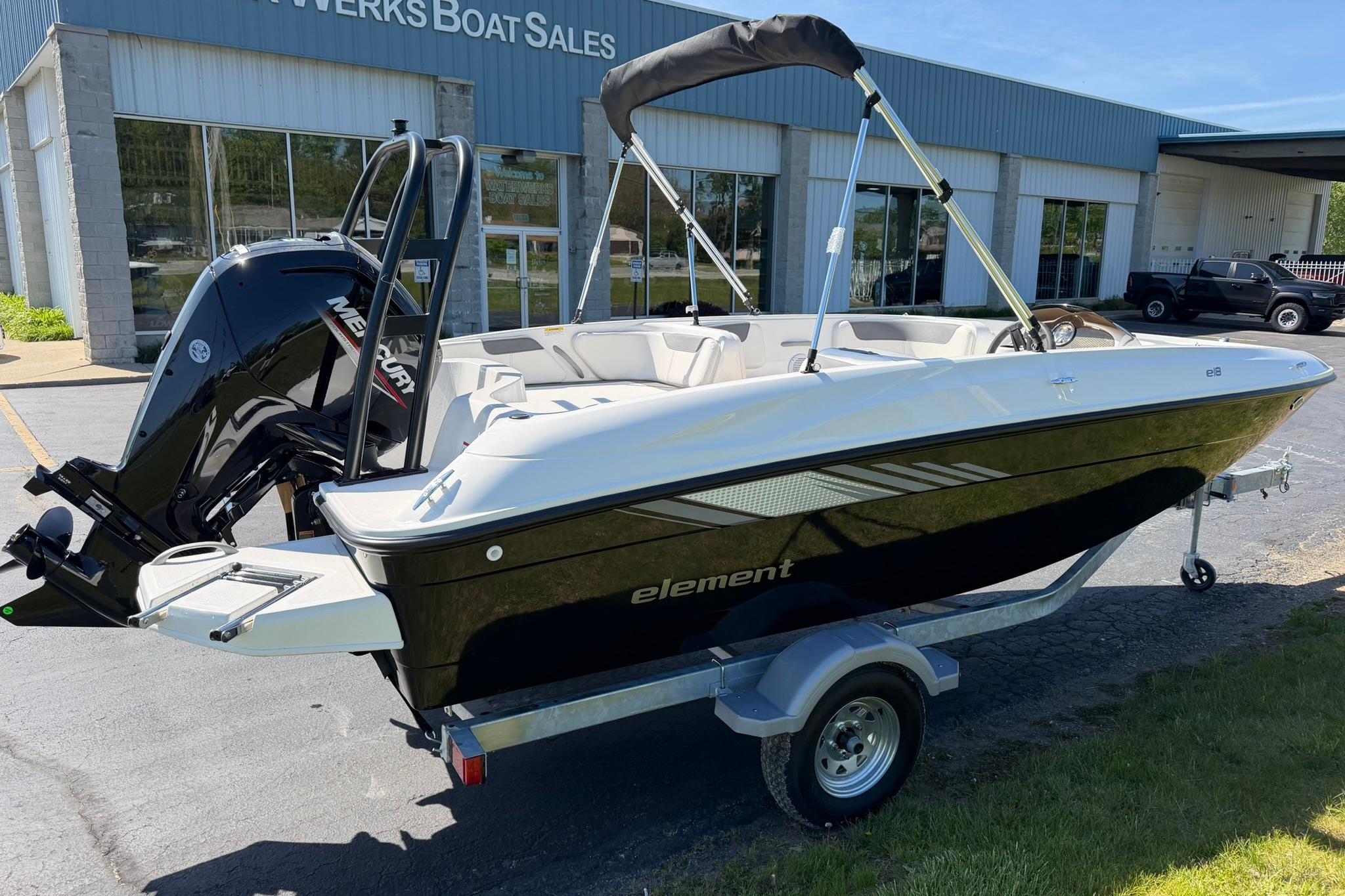 2026 Bayliner Element E18 boat on trailer outside dealership, featuring sleek design and Mercury engine.
