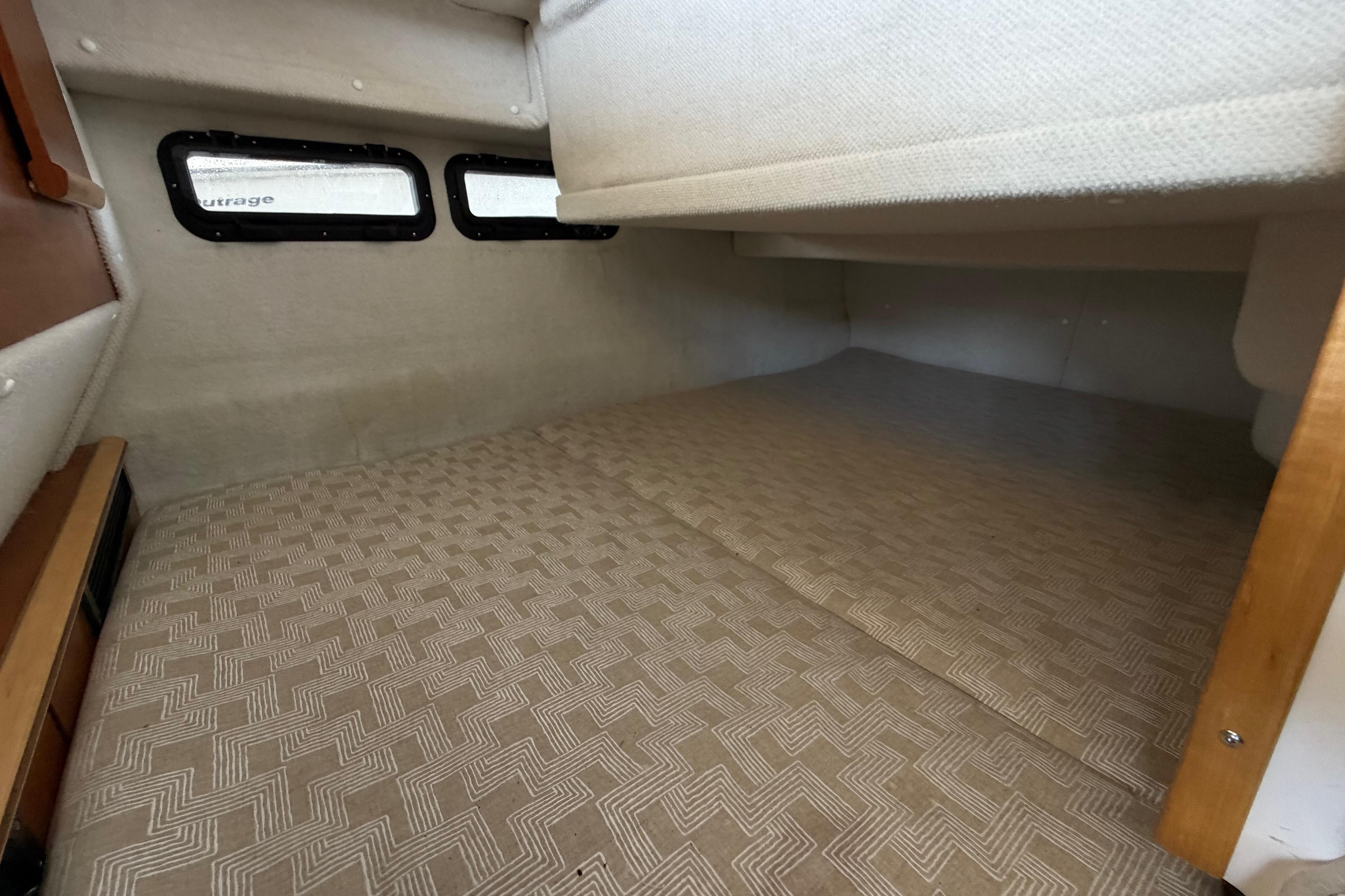 Interior cabin space of 2023 Cutwater C-288 Coupe with patterned flooring and small windows.