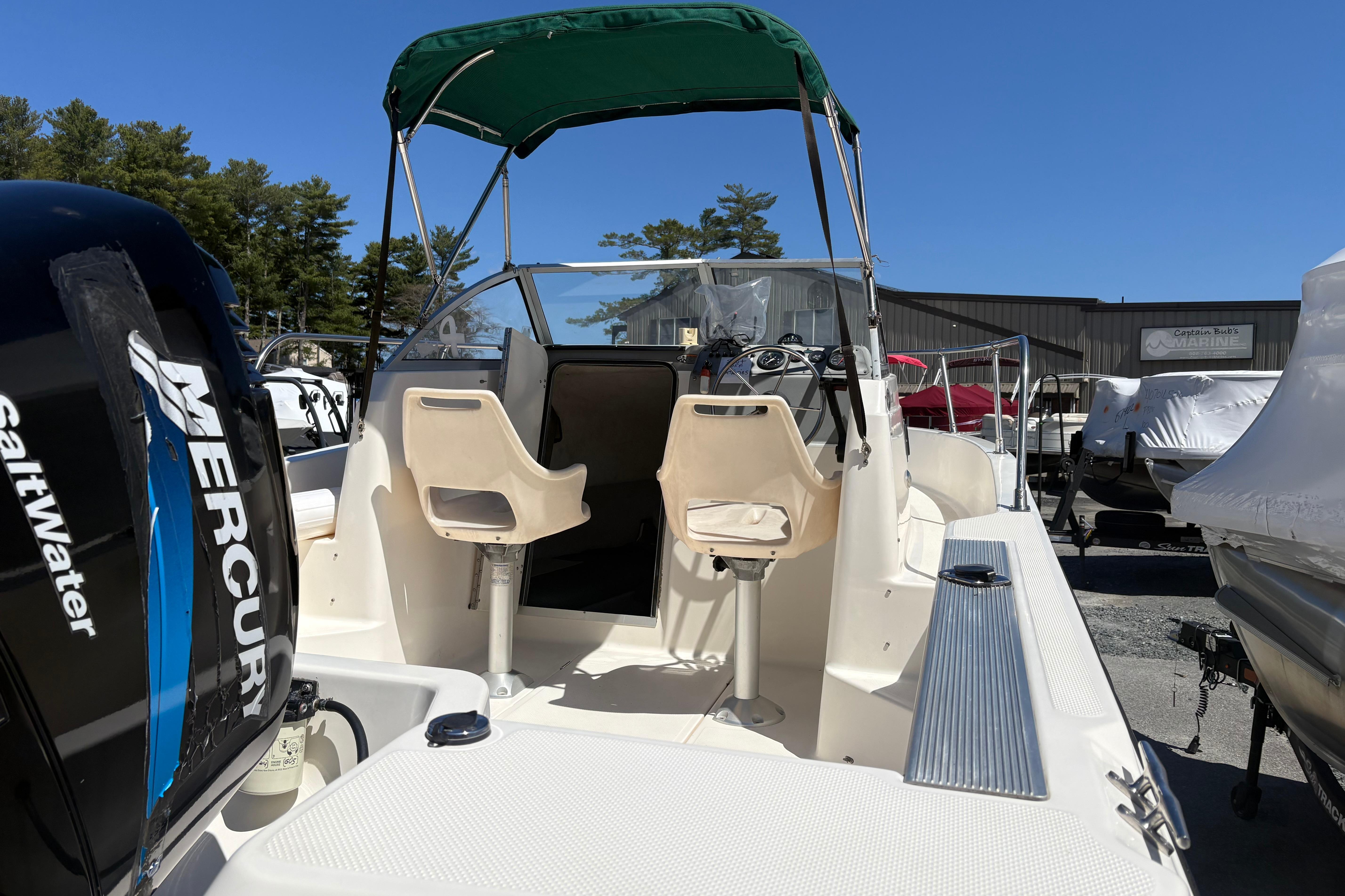 2004 Trophy 1802 Walkaround boat with Mercury engine, featuring dual seats and green canopy.