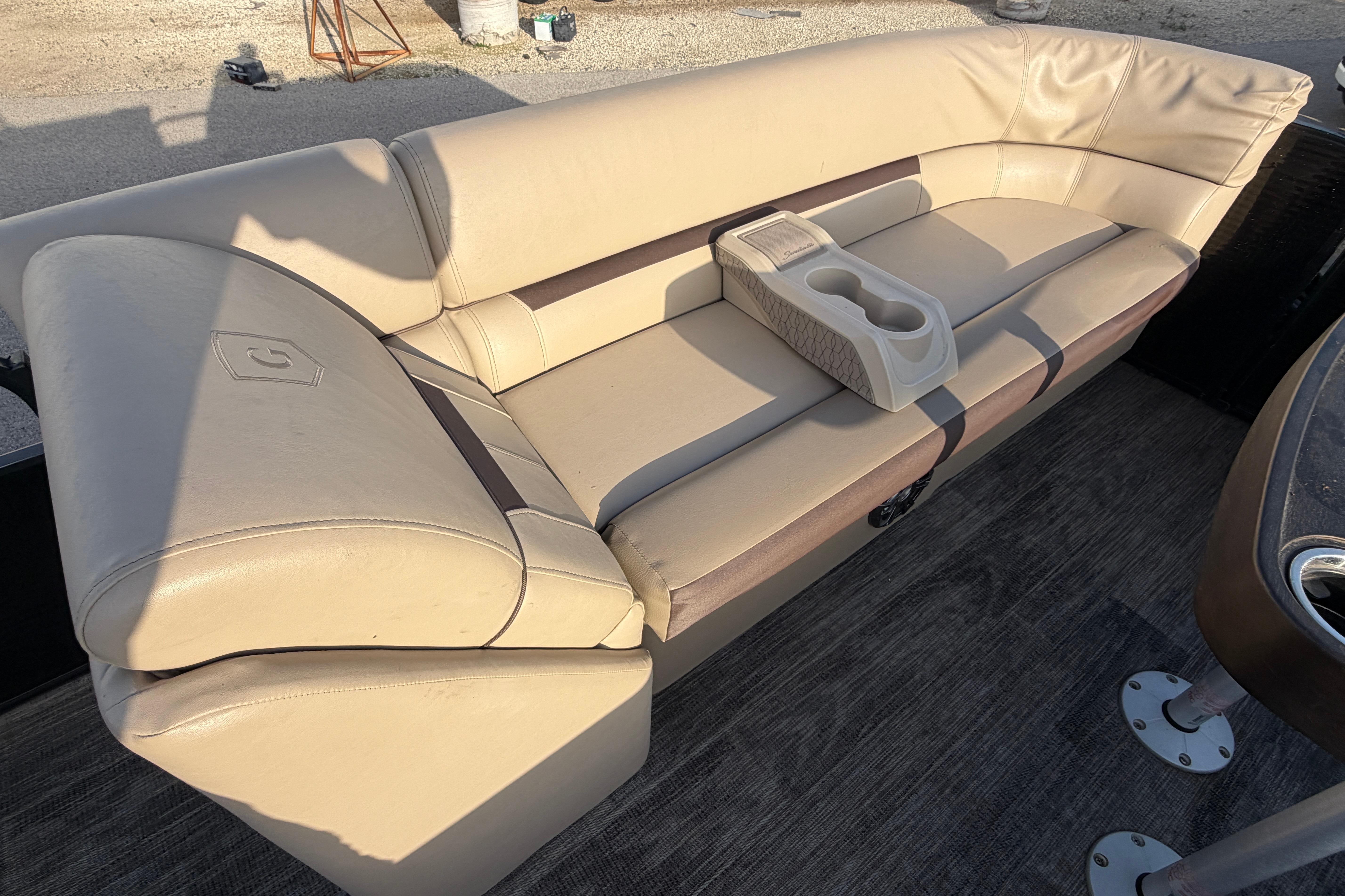 2023 Godfrey Sweetwater 2286 C boat interior with beige seating and cup holders.
