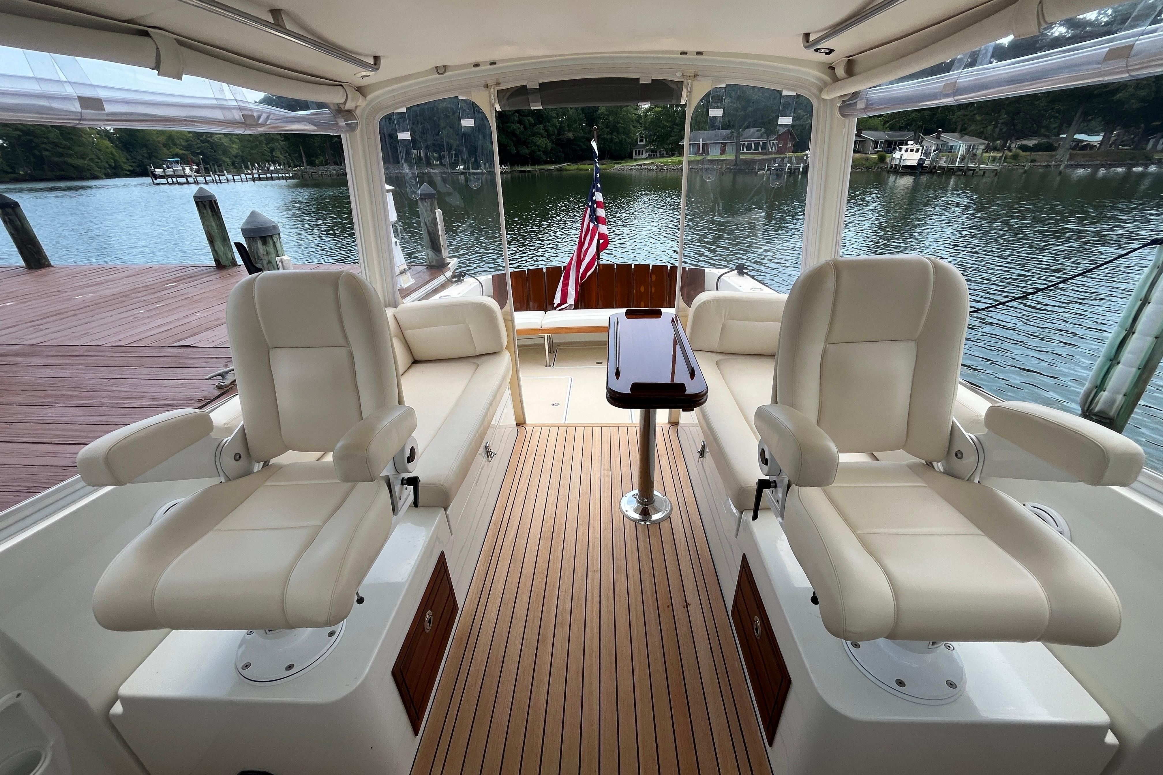 2006 MJM 34z yacht interior with plush seating and wooden deck by the water.