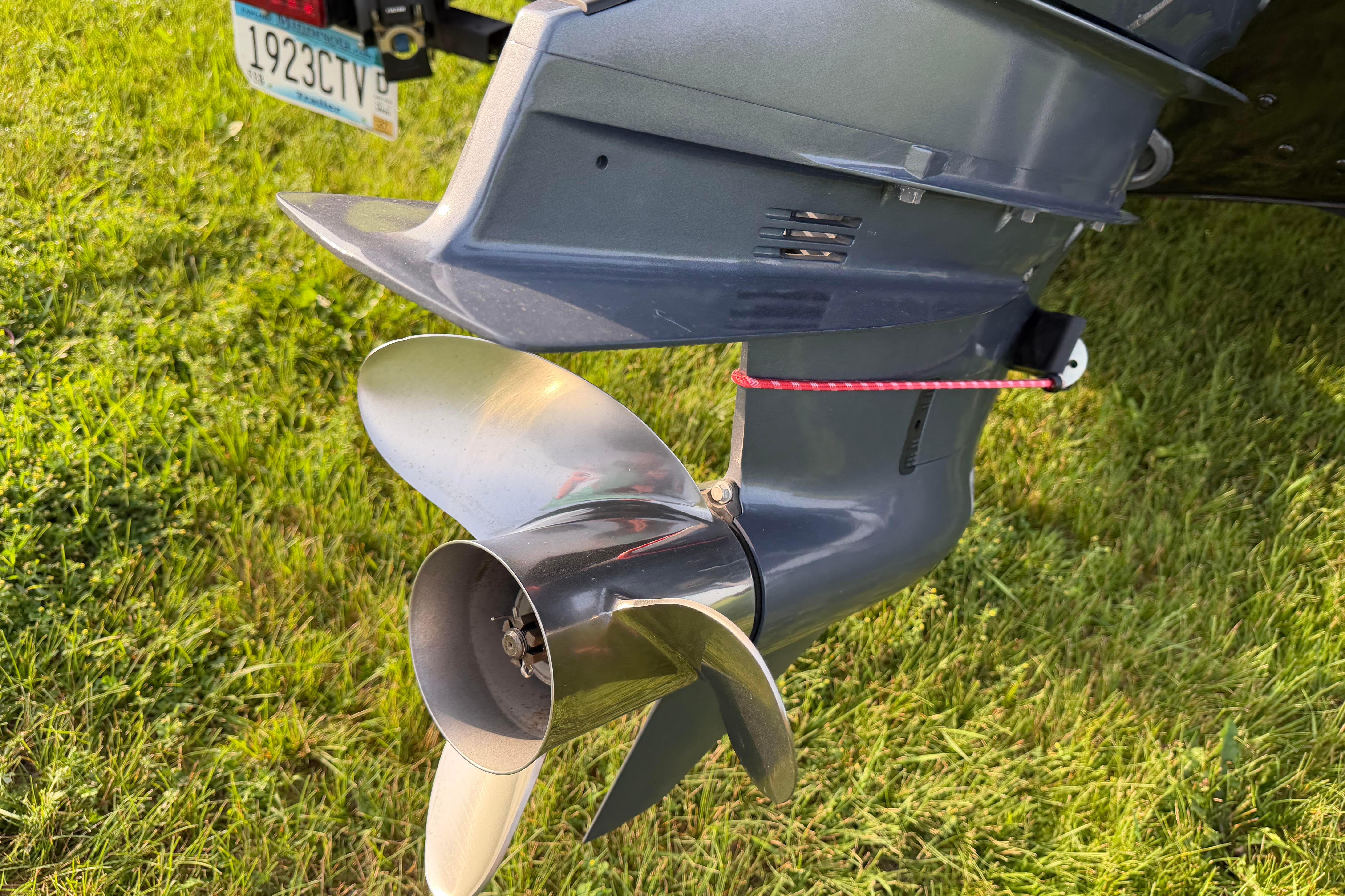 2019 Alumacraft Trophy 205 boat motor and propeller on grass.
