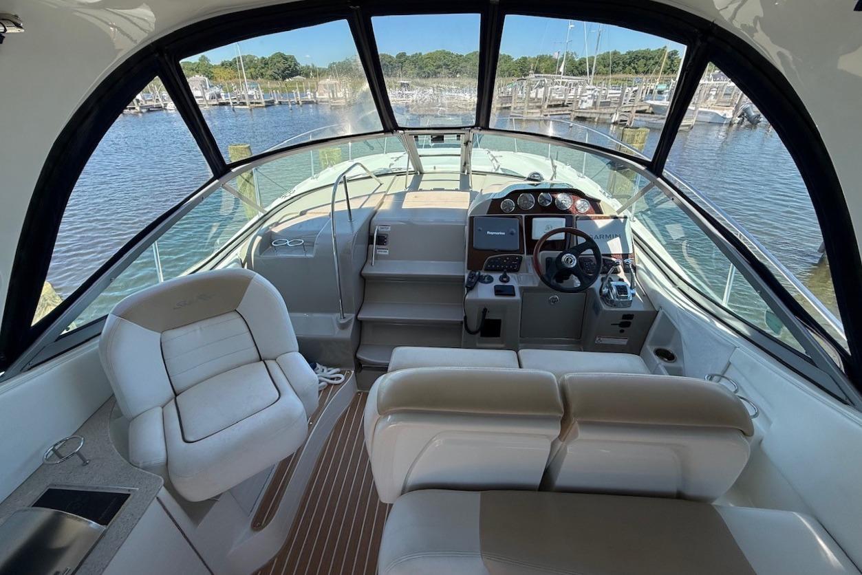 2008 Sea Ray Sundancer 330 cockpit with helm, seating, and marina view.