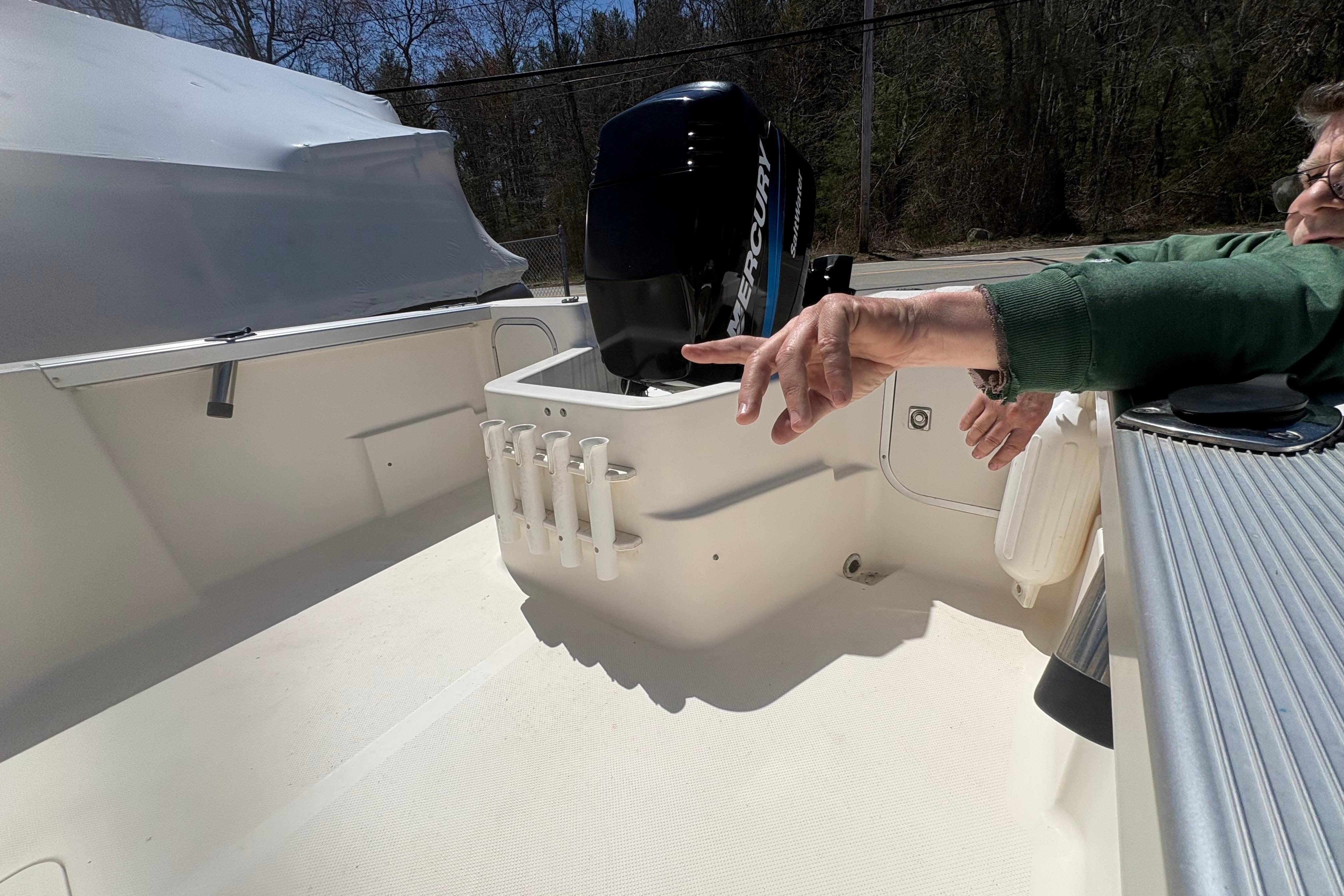 2004 Trophy 1802 Walkaround boat interior with Mercury engine and rod holders.